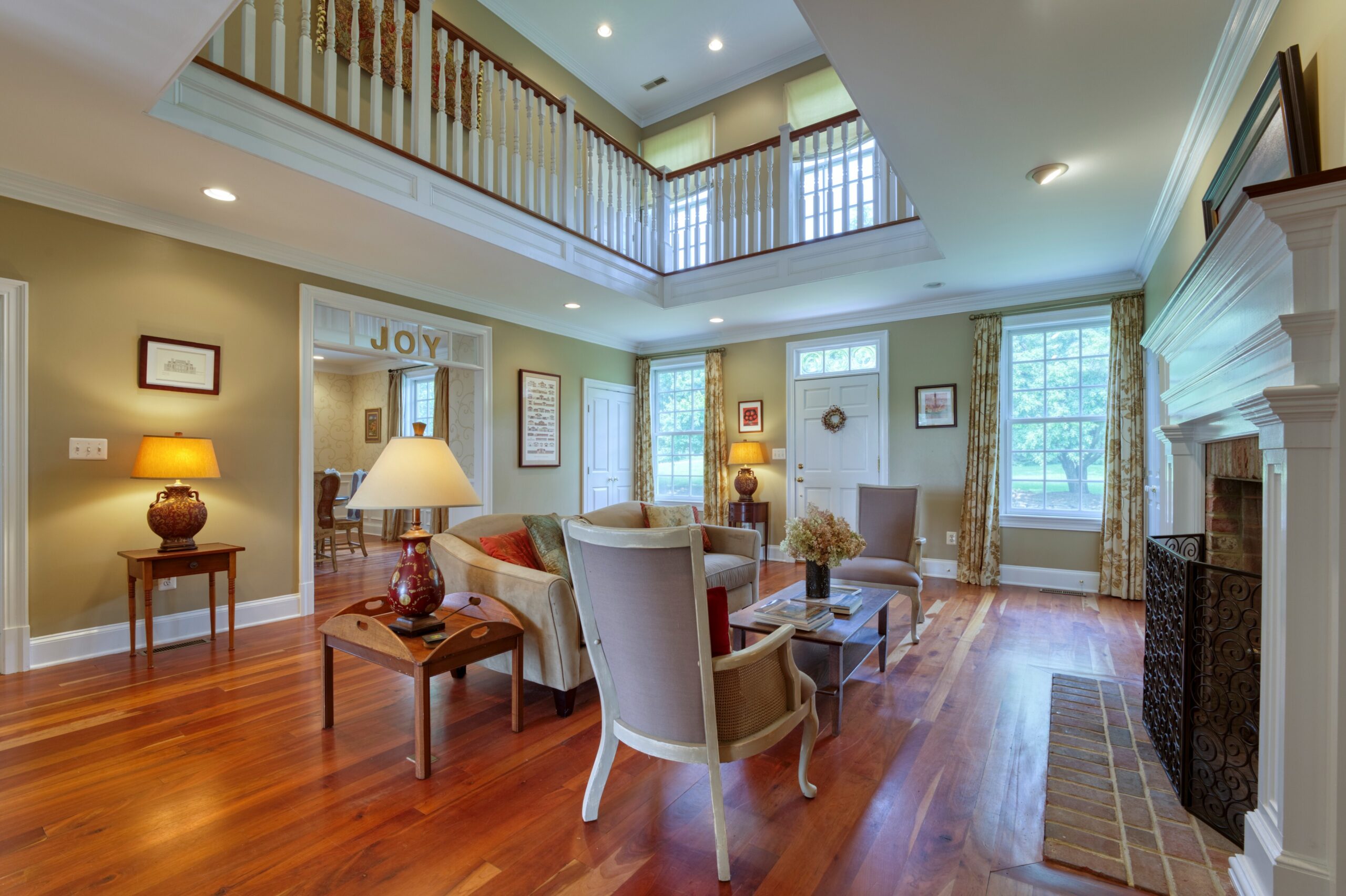 Professional interior photo of 15203 Clover Hill Road - showing the formal living room with cherry hardwood floors and widows walk above