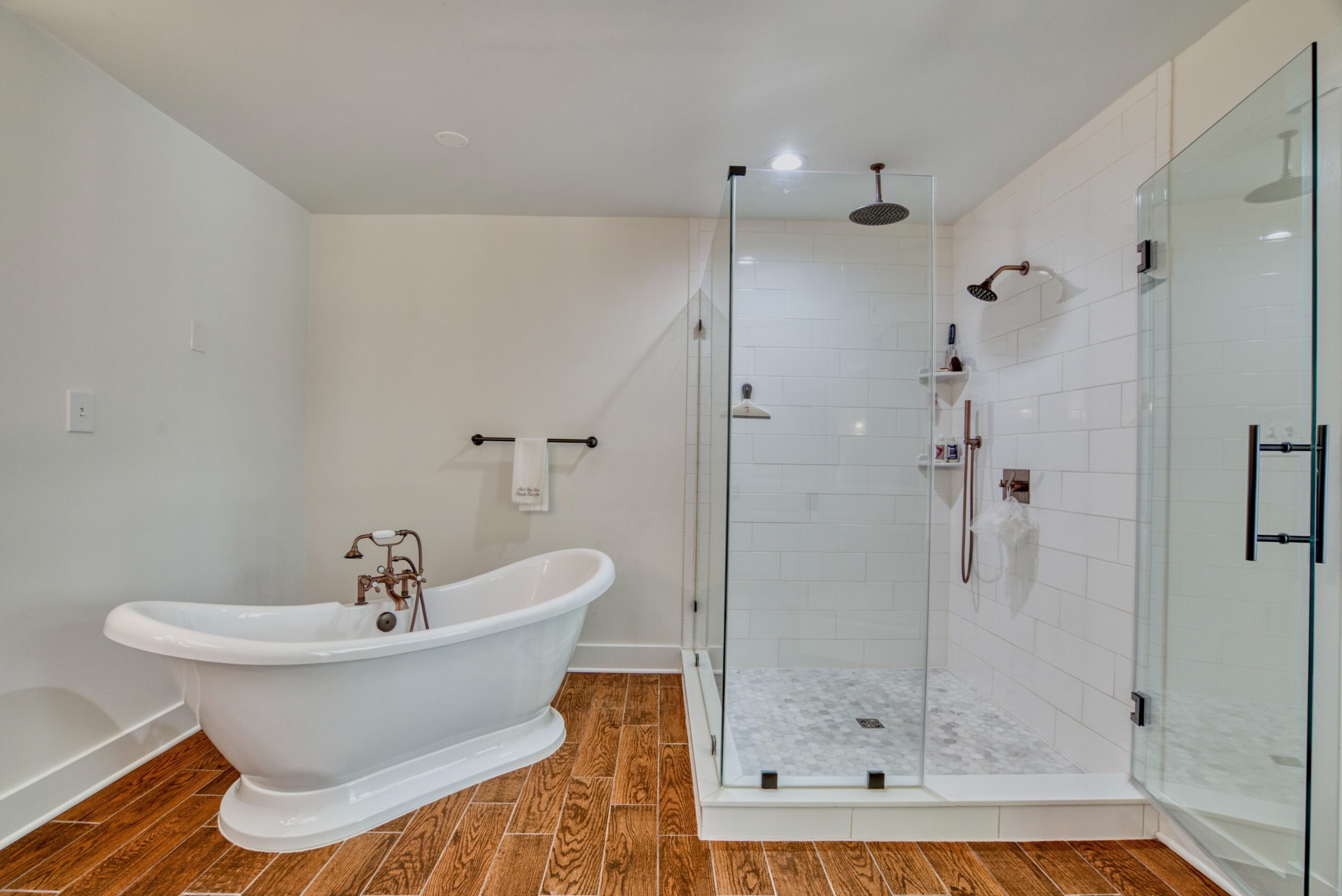 Professional interior photo of 209 Norwood Road, Annapolis, MD - showing the primary bathroom with soaking tub next to large glass shower with rain head