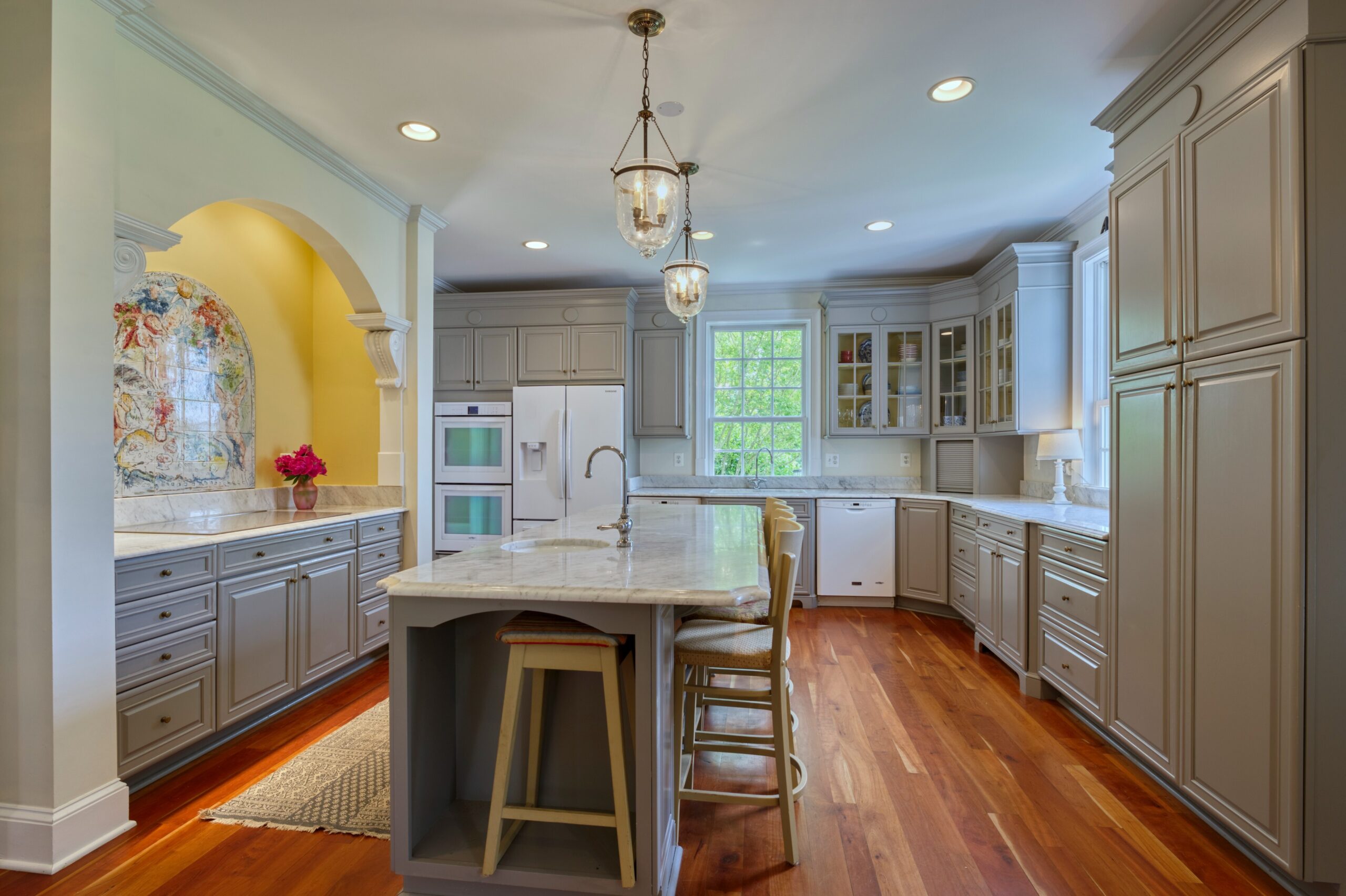 Professional interior photo of 15203 Clover Hill Road - showing the remodeled kitchen with grey cabinets, white granite countertops, white appliances, and large island with sink