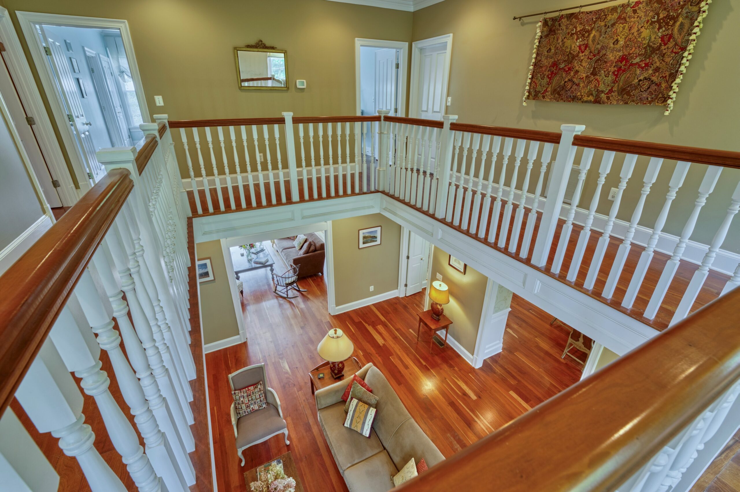Professional interior photo of 15203 Clover Hill Road - showing the view from the 2nd floor widow's walk looking down to the formal living room and cherry floors
