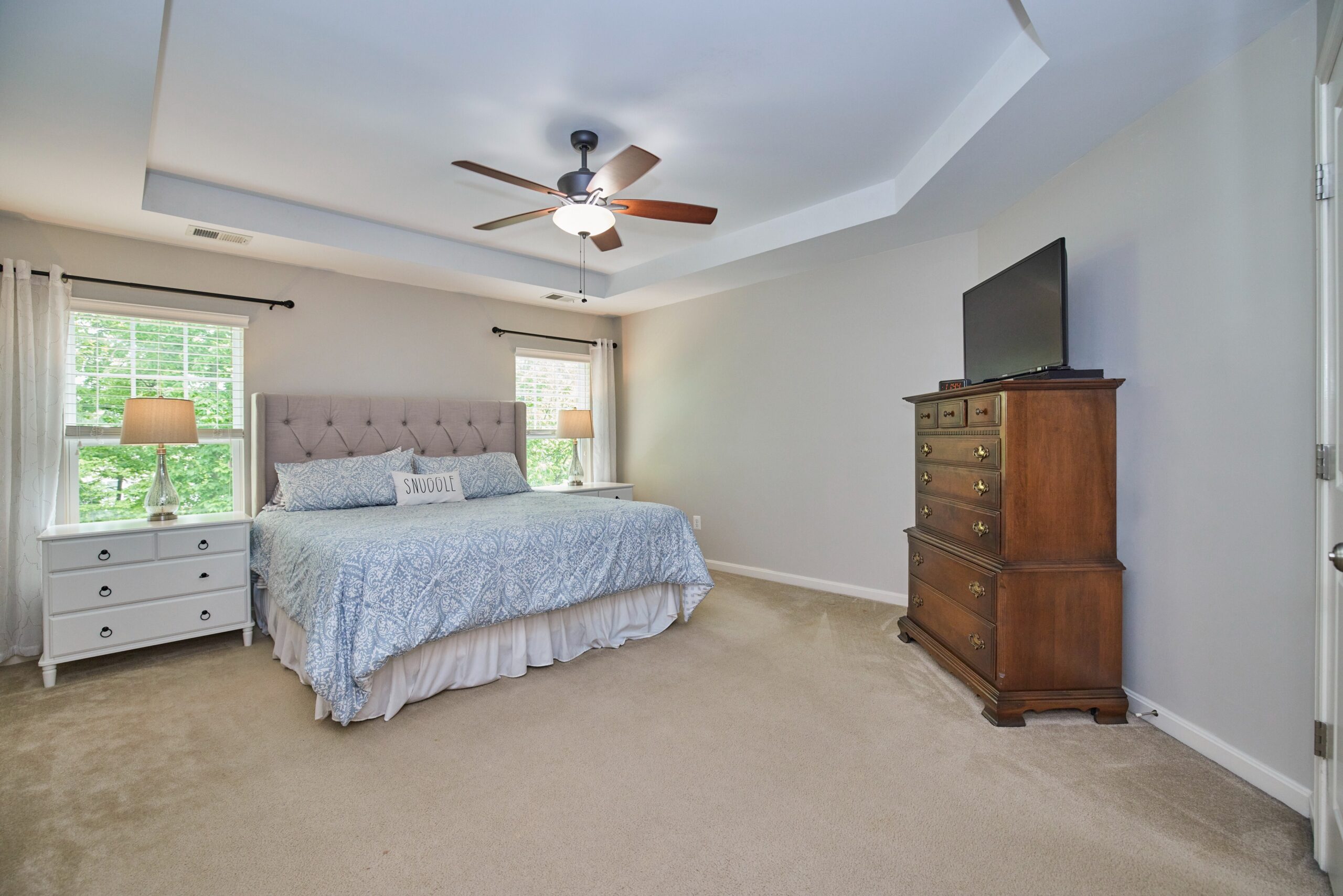 Professional interior photo of 12030 Lake Dorian Drive, Bristow, VA - showing the primary bedroom with trey ceiling and king size bed flanked by windows
