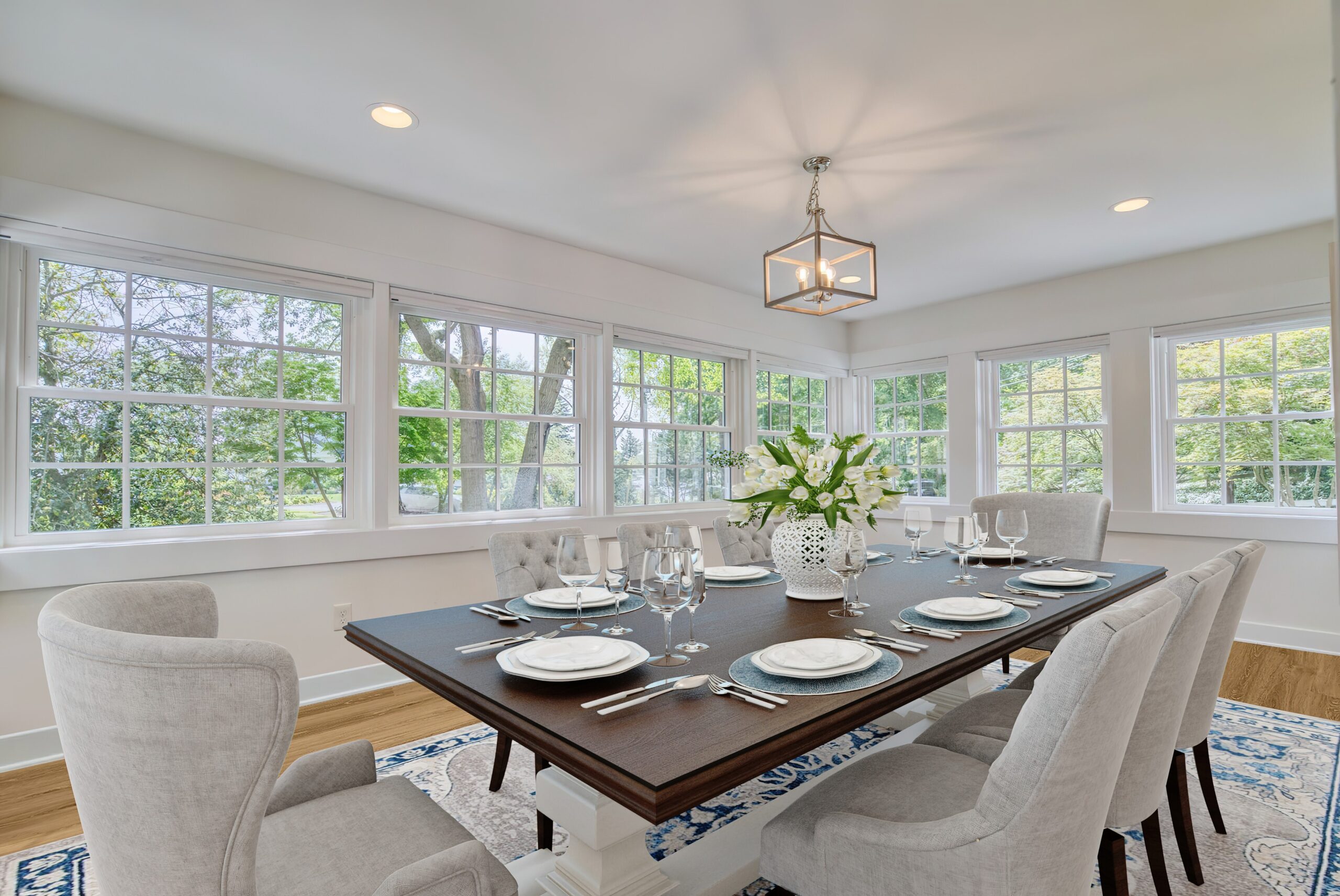 Professional interior photo of 209 Norwood Road, Annapolis, MD - showing the sunroom which us being used as the dining room with windows on all sides and hardwood floors