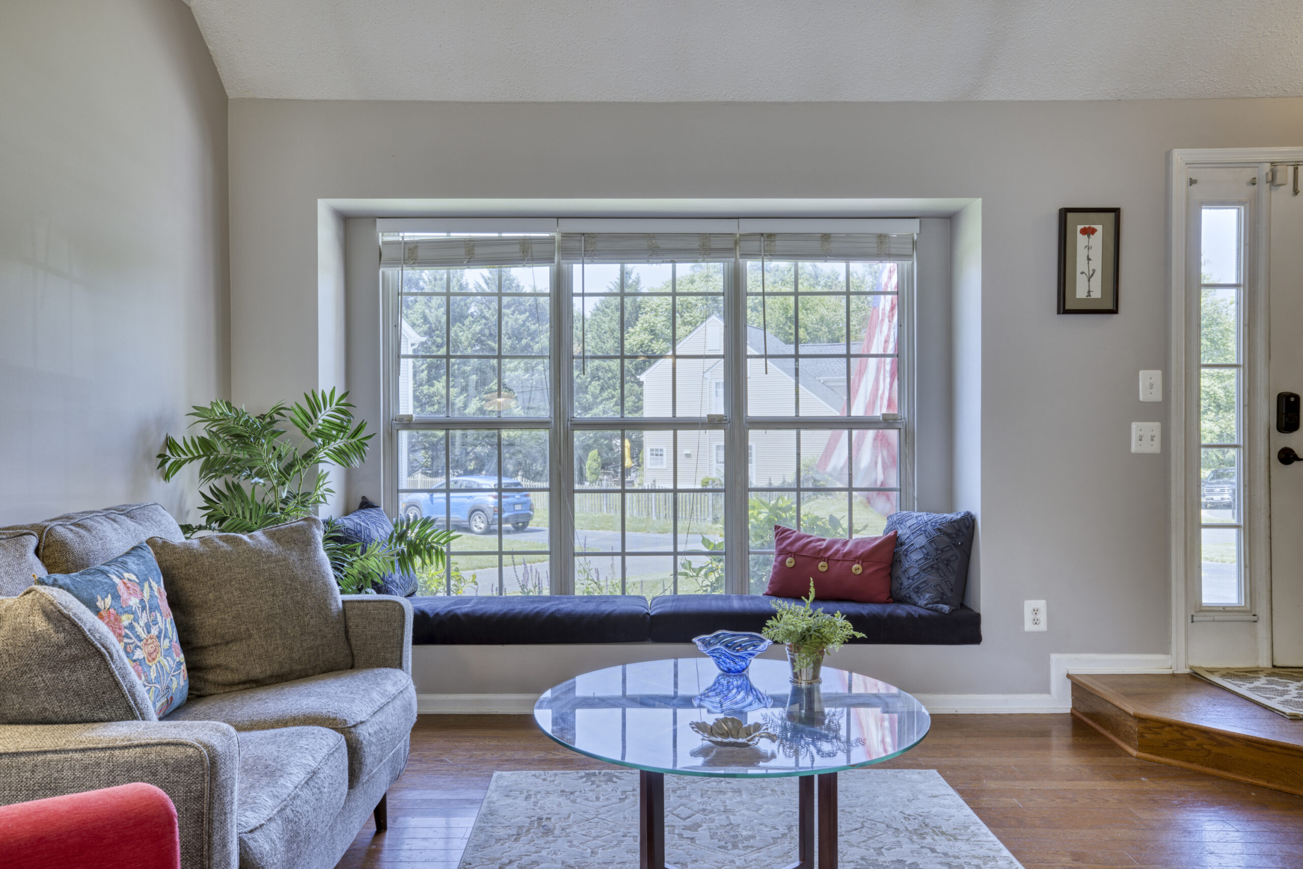 Professional interior photo of 12309 Stalwart Court - showing the front living room looking towards the front window where there is a window seat with blue cushions