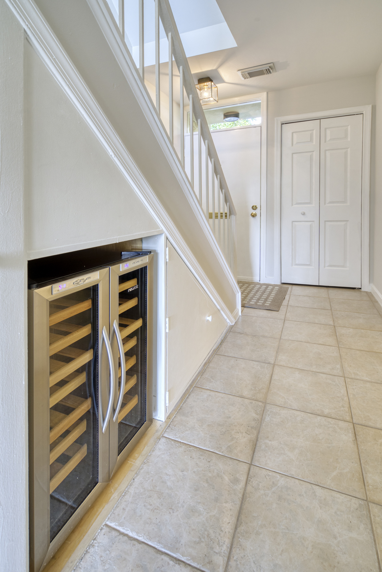 Professional interior photo of 1215 N Nash St #1, Arlington - showing the first floor hall to the staircase with a build in wine cooler under the stairs