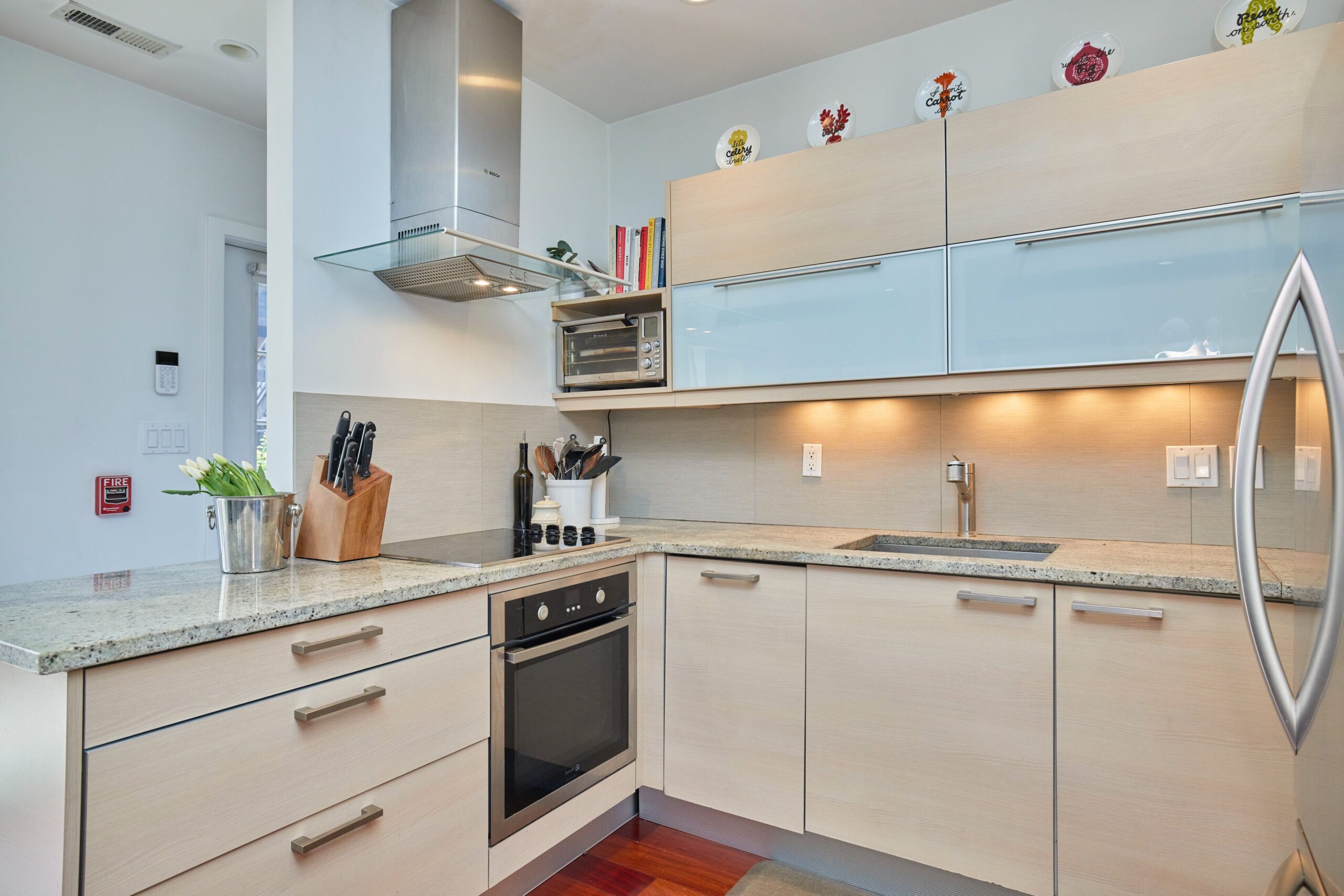 Professional interior photo of 1459 Harvard St NW #6 - showing the kitchen with beige cabinets, granite counters and stainless built-in appliances
