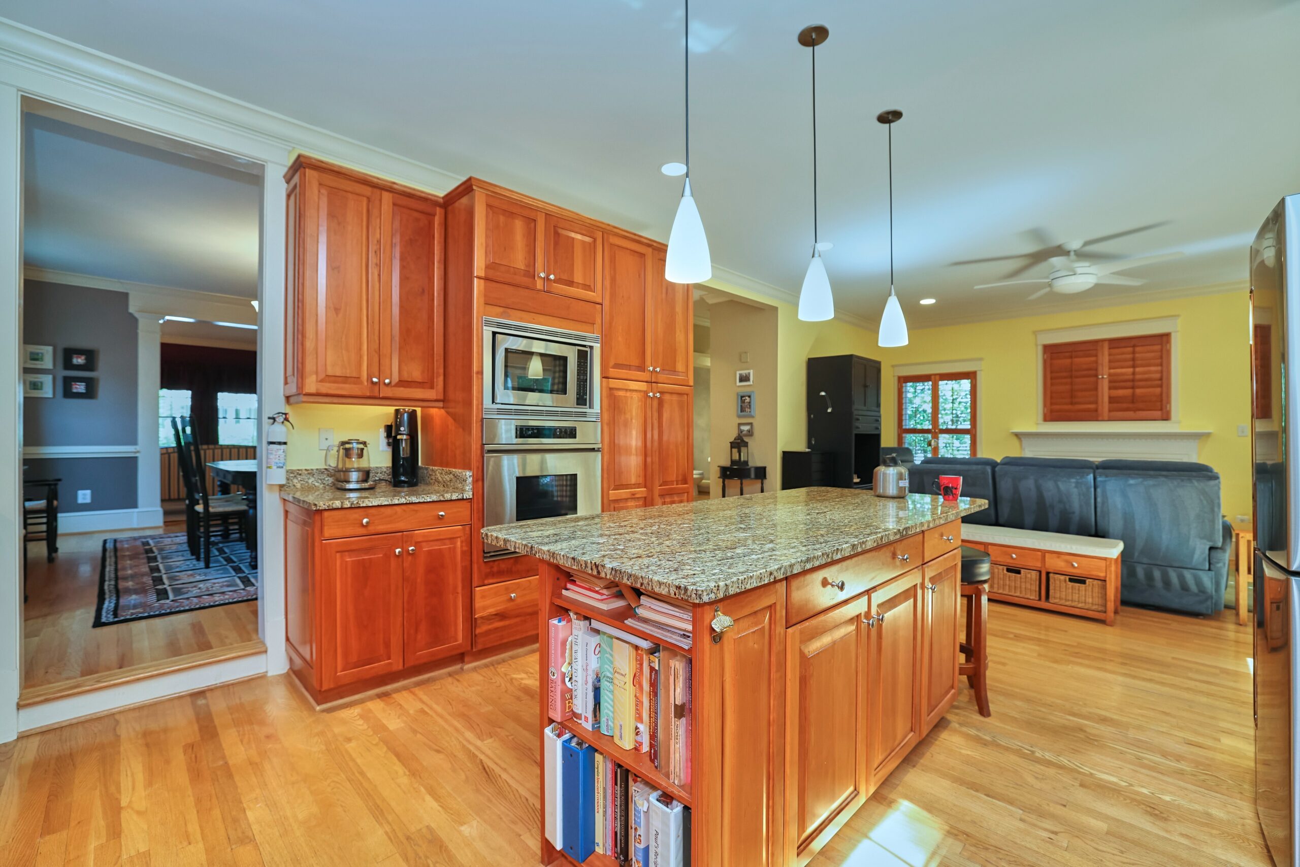 Professional interior photo of 819 N Fillmore St - Showing the kitchen with cherry cabinets, granite counters, hardwood floors, and a large island with built-in cookbook shelf