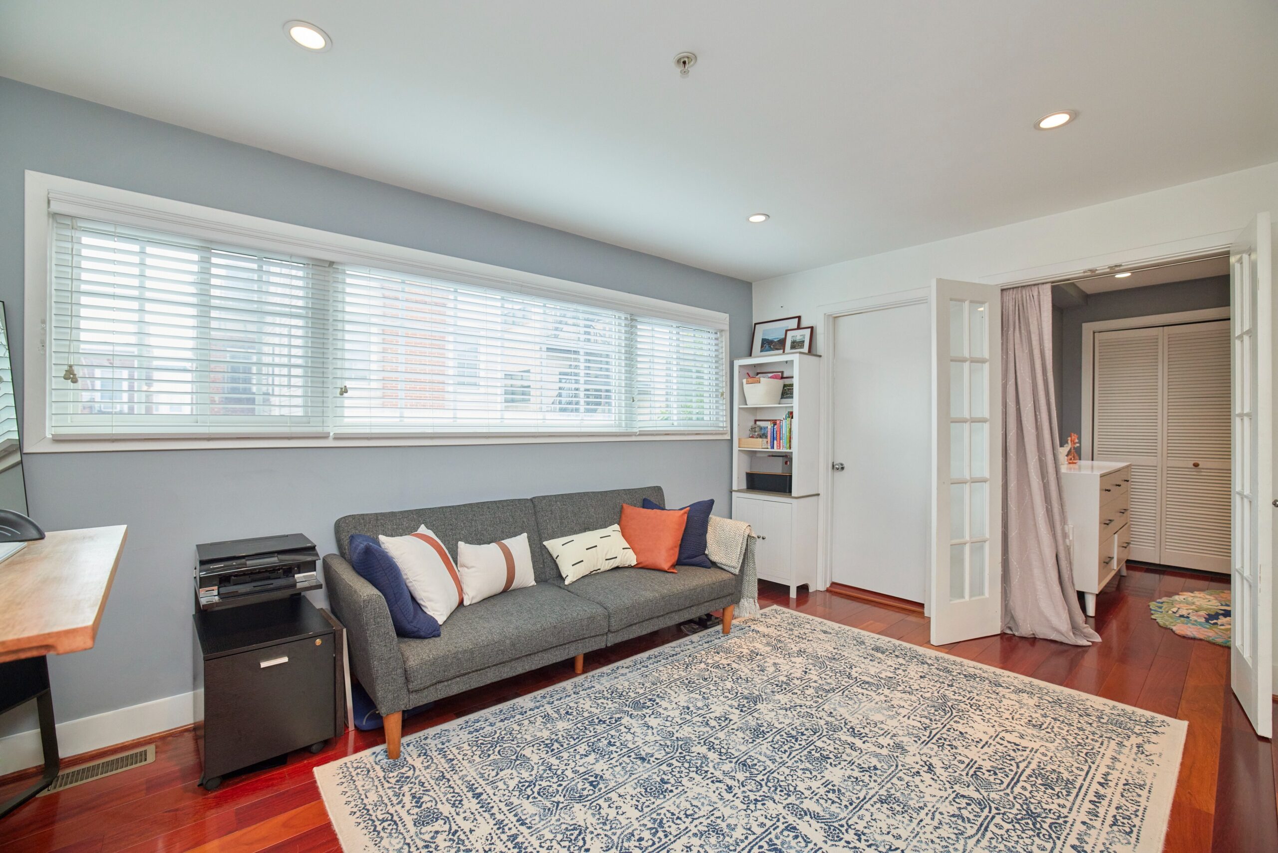 Professional interior photo of 1459 Harvard St NW #6 - showing the loft area with desk and couch and door to bathroom