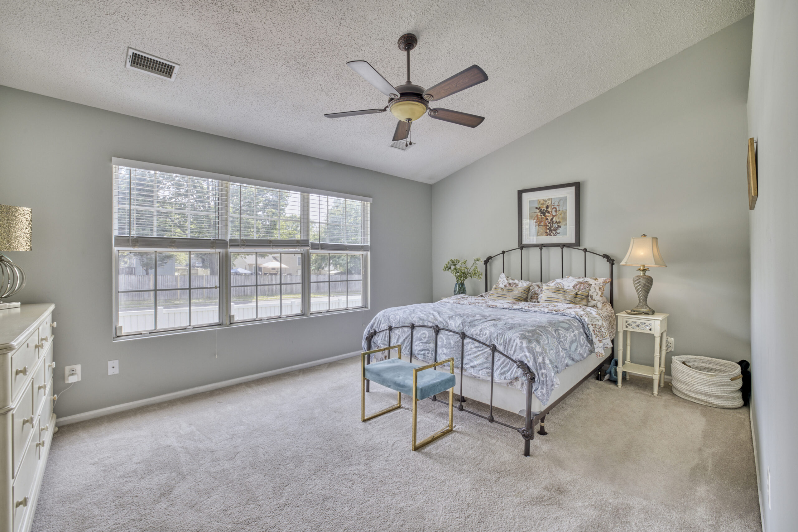 Professional interior photo of 12309 Stalwart Court - showing the primary bedroom with vaulted ceiling, cream carpeting and large windows