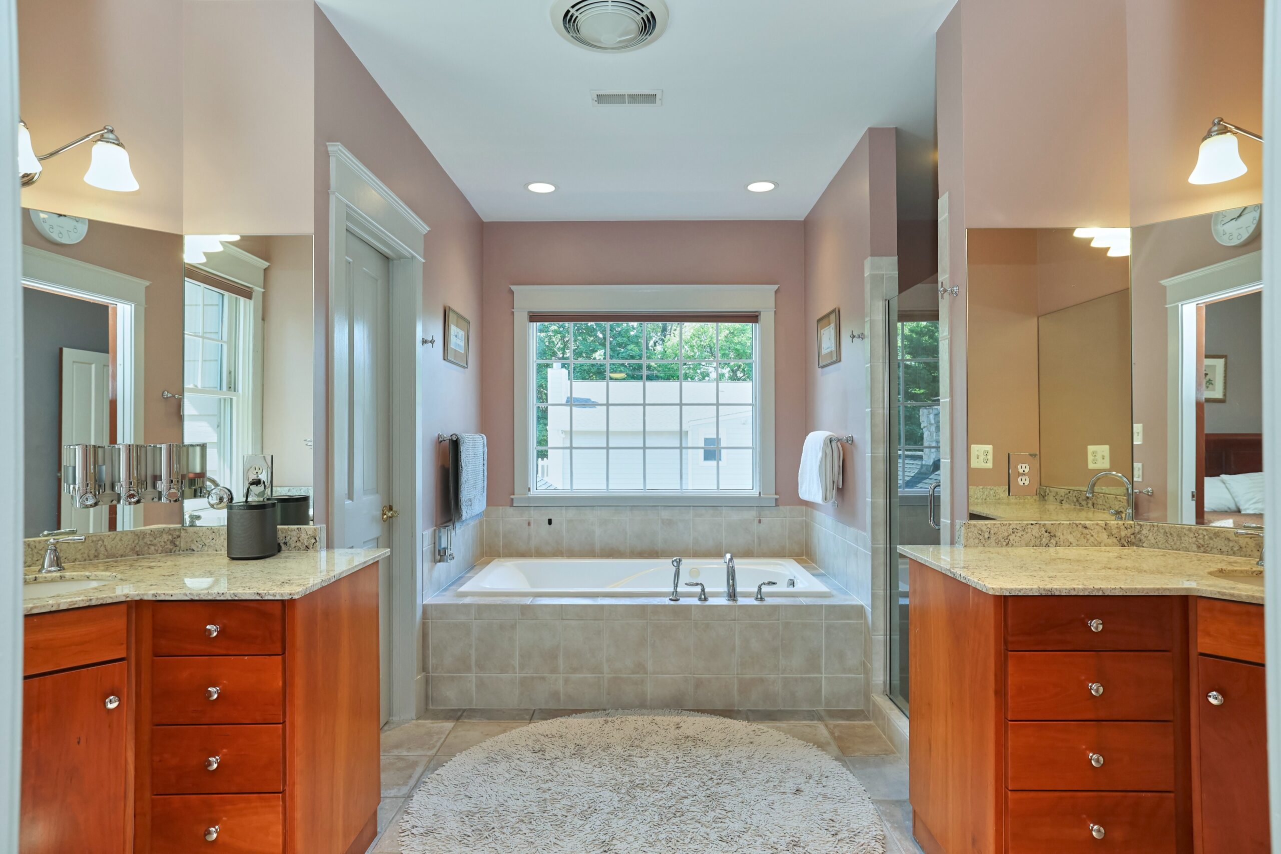 Professional interior photo of 819 N Fillmore St - Showing the primary bathroom with 2 individual vanities and a deep soaking tub visible toward the back