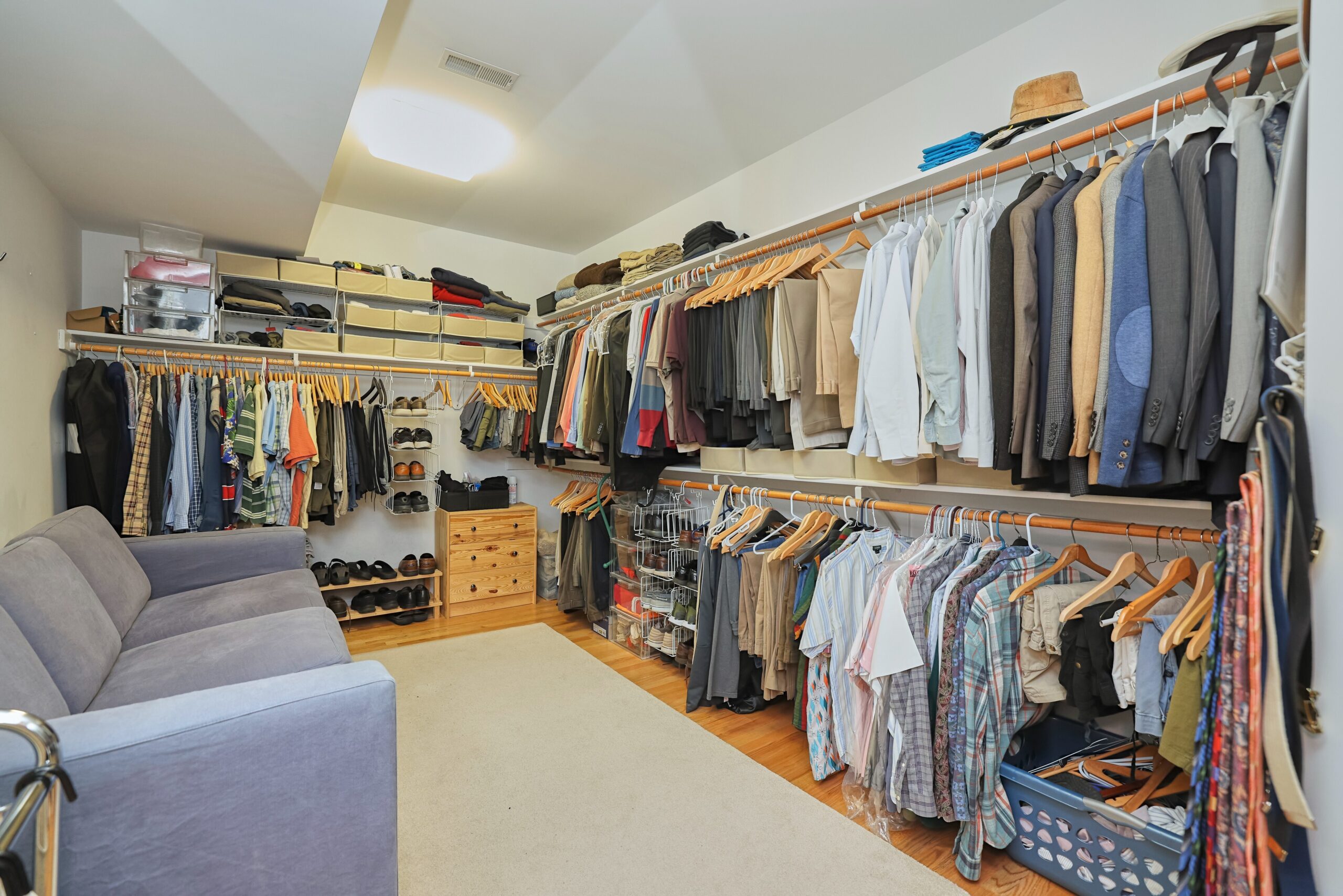 Professional interior photo of 819 N Fillmore St - Showing the large walk-in closet with built-in racks and shelves and space for a couch