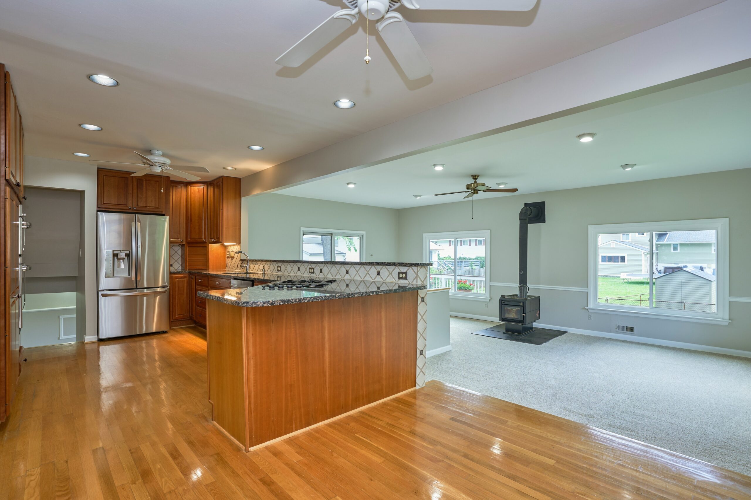 Professional interior photo of 5803 Sable Drive, Alexandria, VA - showing the recessed living room which is a 2 steps down from the kitchen with cherry cabinets in the foreground