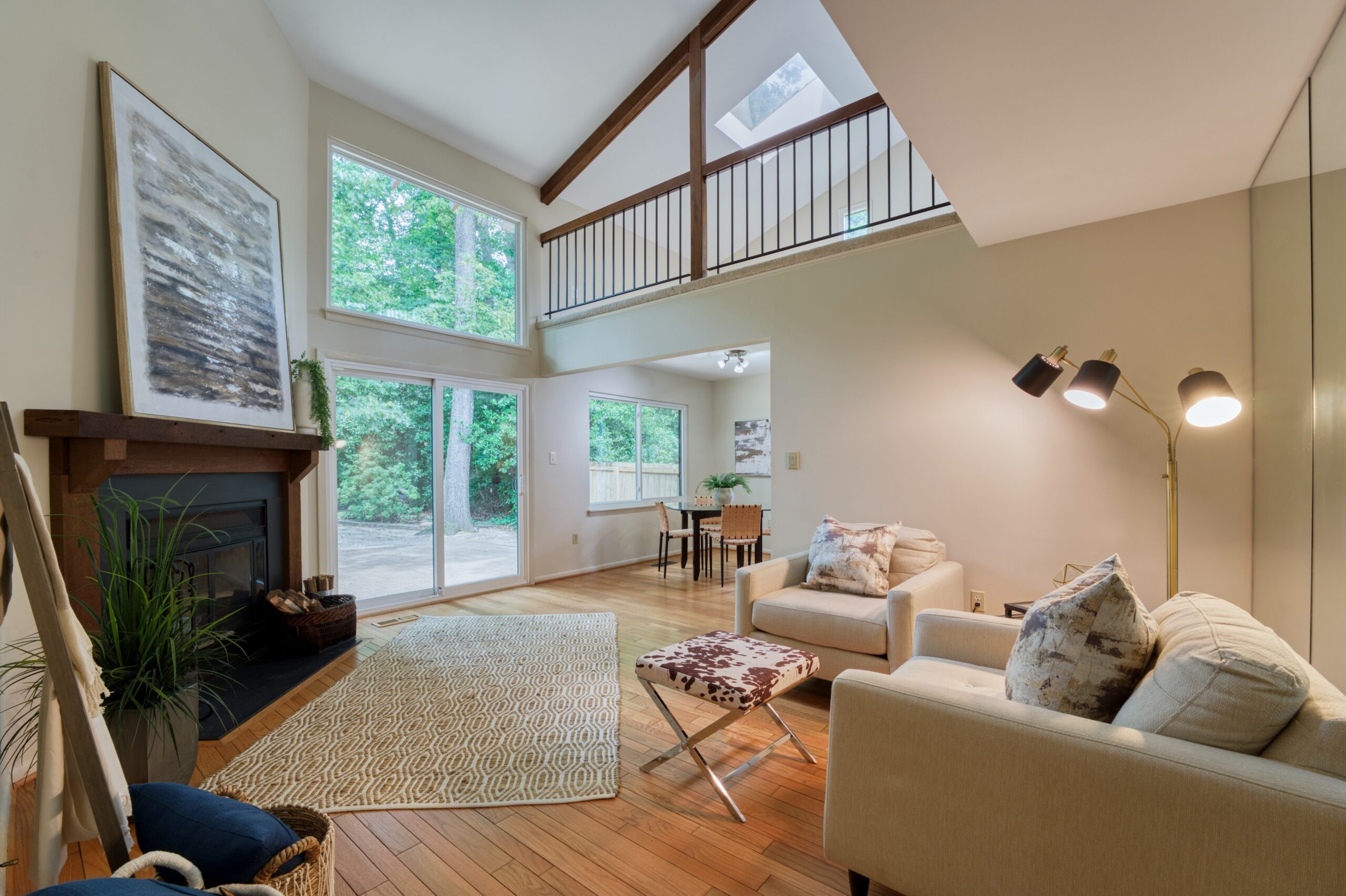 Professional interior photo of 5222 Bradfield Dr in Burke, Virginia - showing the living room with fireplace and vaulted ceiling and hardwood floors