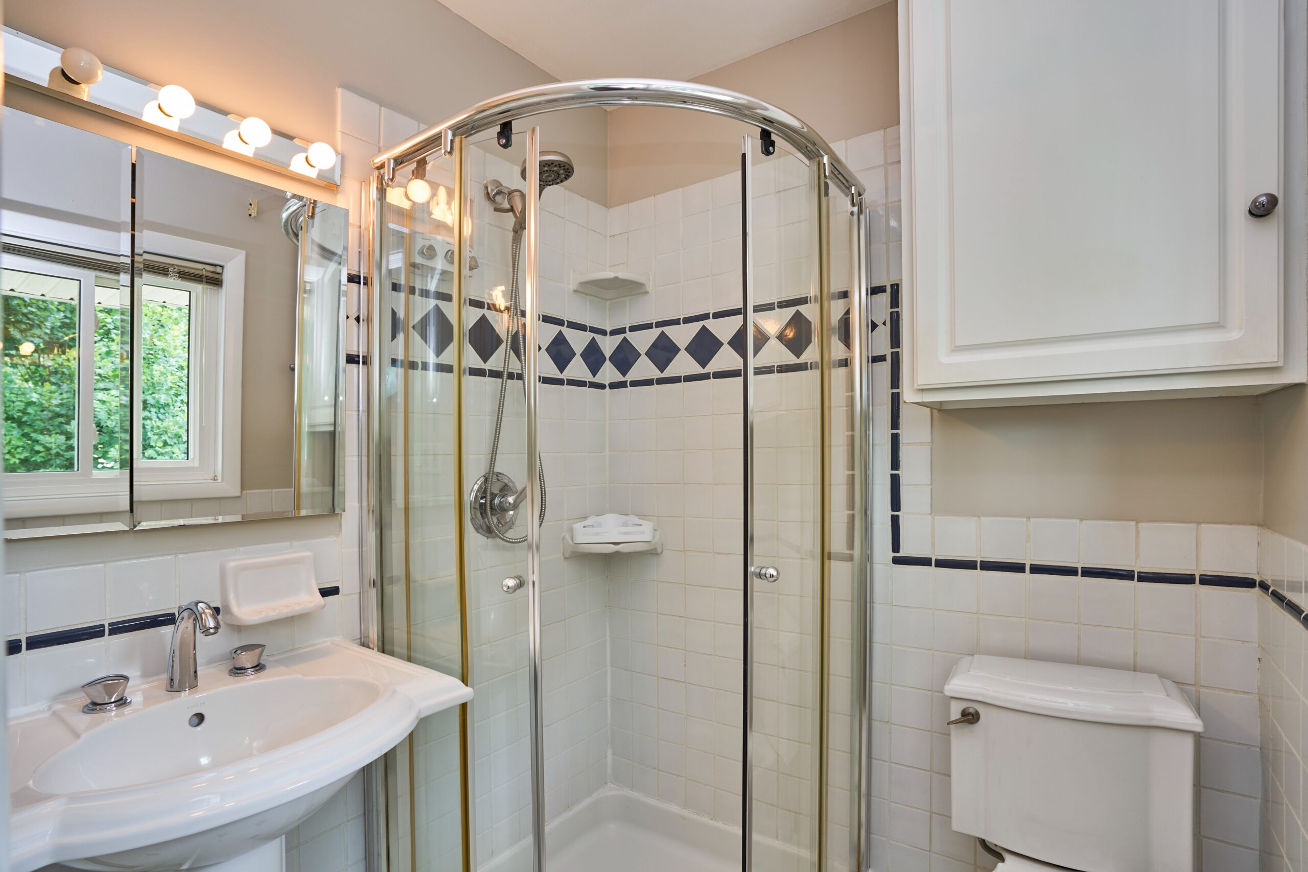 Professional interior photo of 5803 Sable Drive, Alexandria, VA - showing the second full bath with an enclosed glass corner shower 