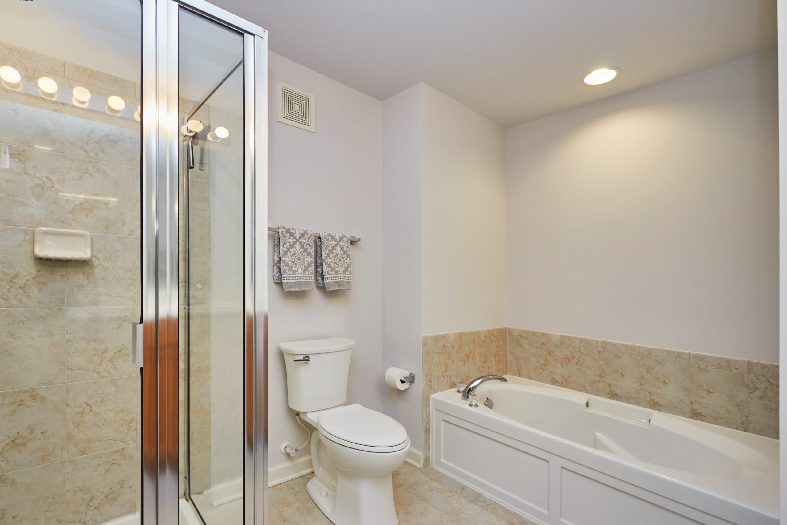 Professional interior photo of 6058 Aster Haven Circle - showing the primary bathroom with deep soaking tub and separate zero entry shower