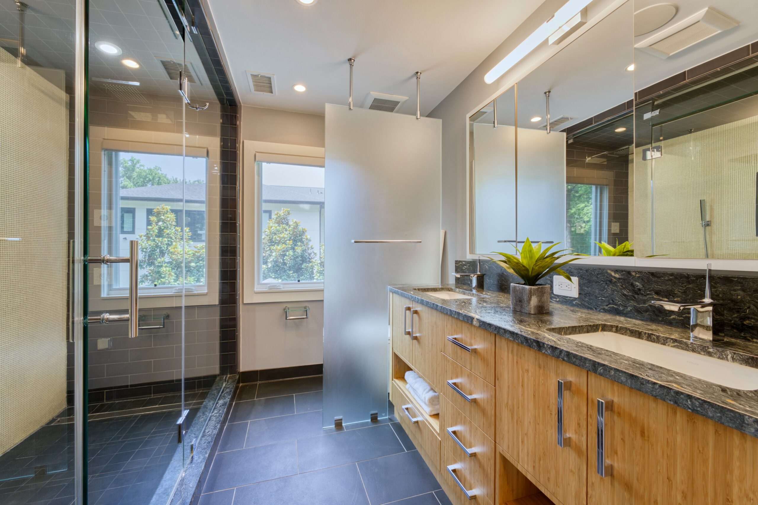 professional interior photo of 3132 Sleepy Hollow Road - showing the primary bathroom with slate floors and huge custom shower on the left side, translucent glass in the background hiding the commode