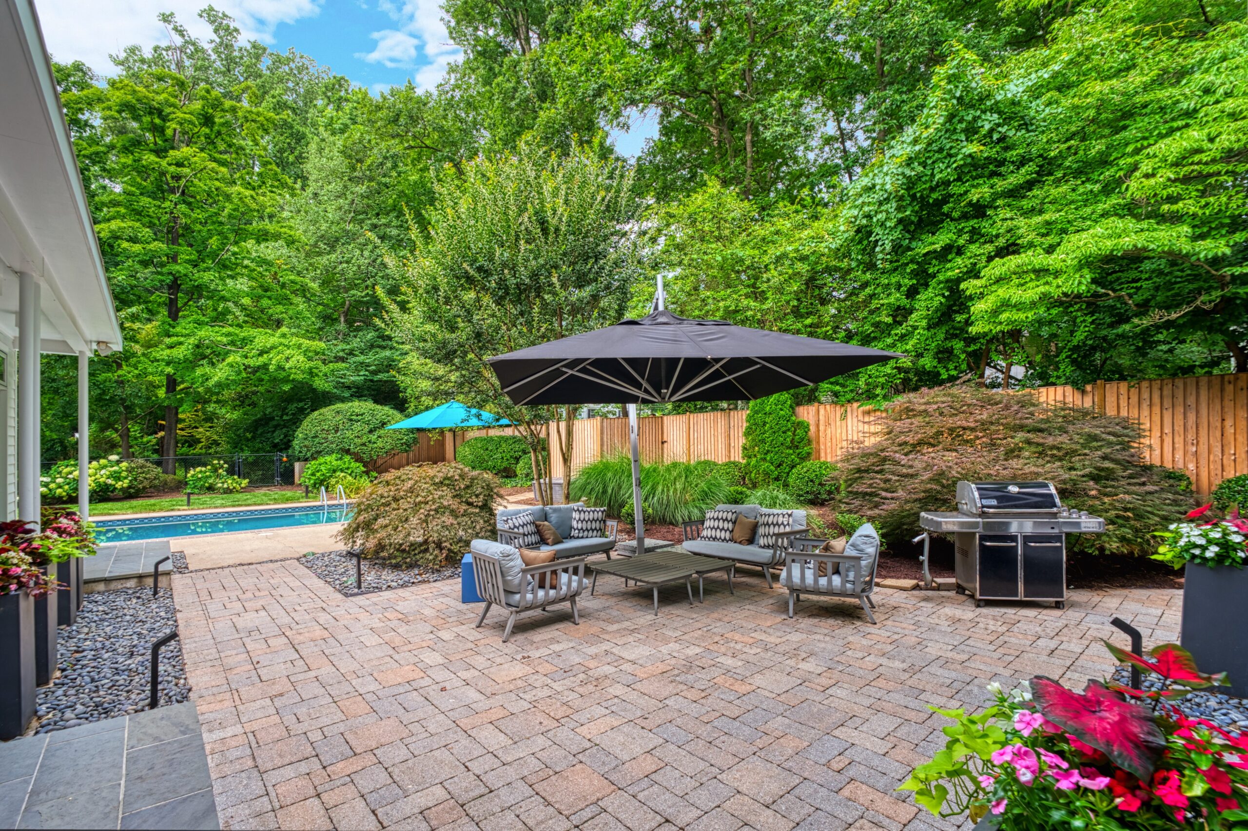 professional exterior photo of 3132 Sleepy Hollow Road - showing the rear from the exit and the expanded patio with patio furniture and grill and pool in the background