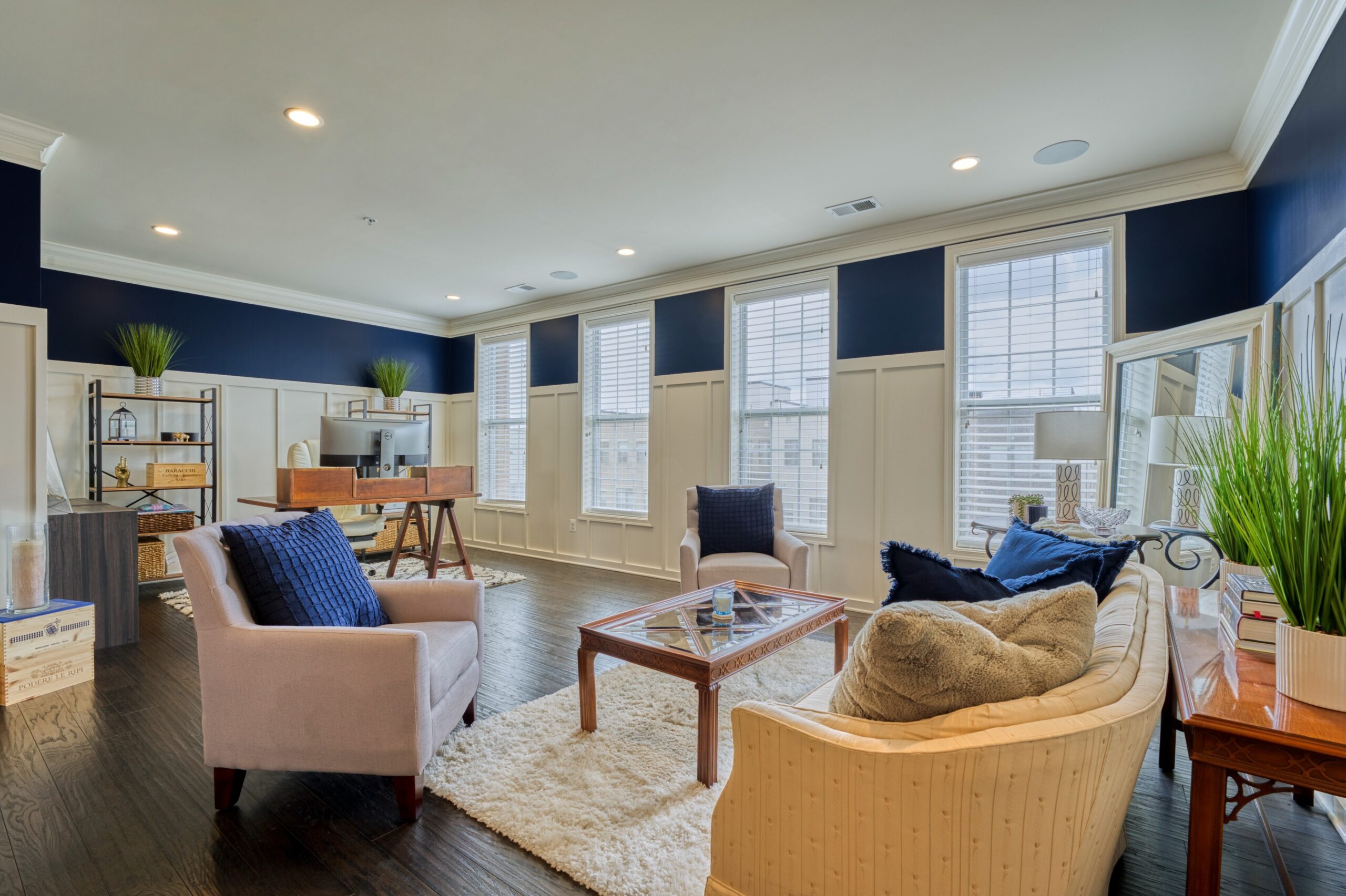 Professional interior photo of 23560 Buckland Farm Ter, Ashburn, VA - Showing the living and office room with white wainscoting against white walls bordered by deep blue around the top third of the wall over the wainscoting