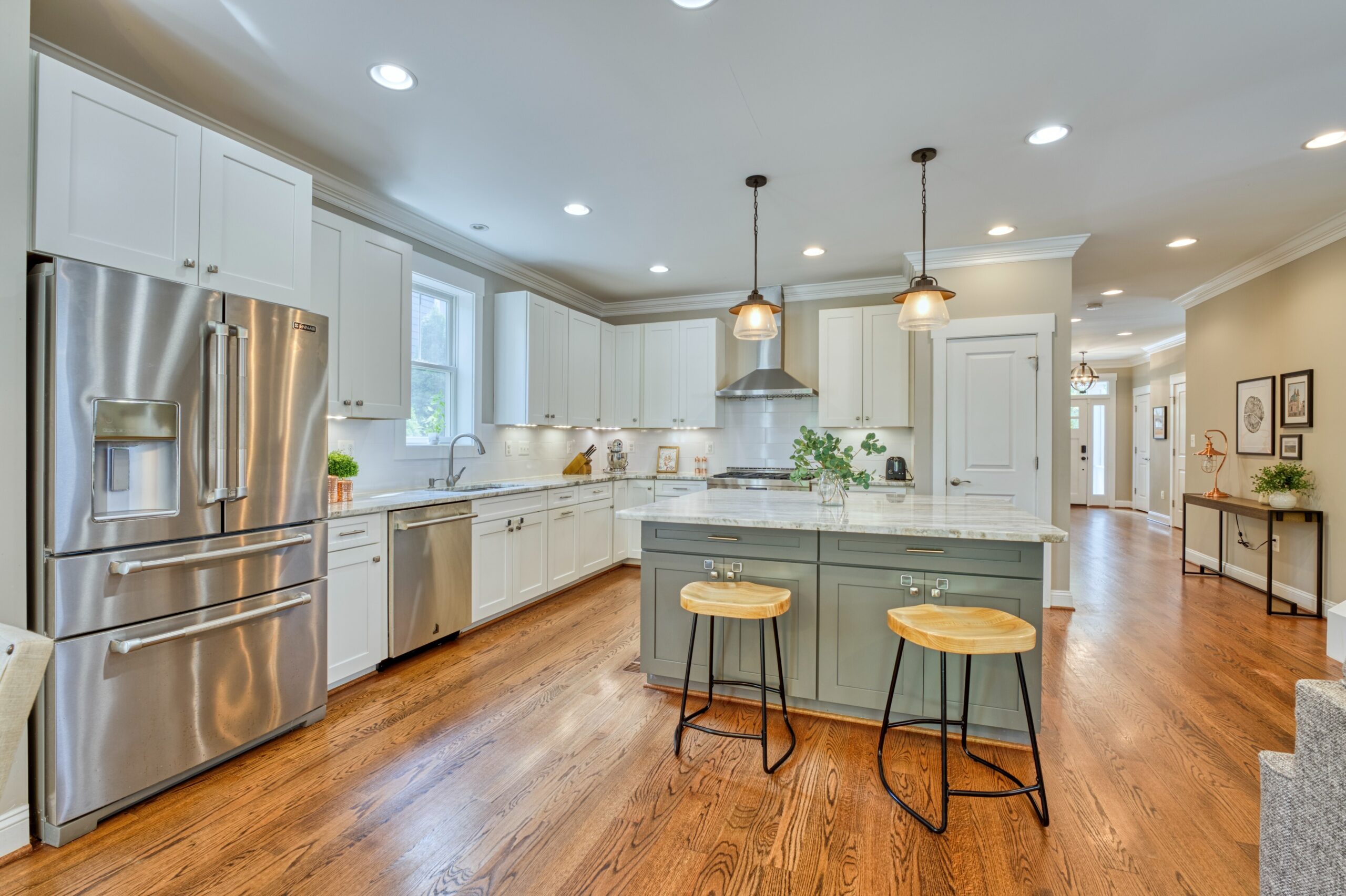 Professional interior photo of 505 N West St - showing the kitchen view from the family room with large island, stools, and quality stainless appliances