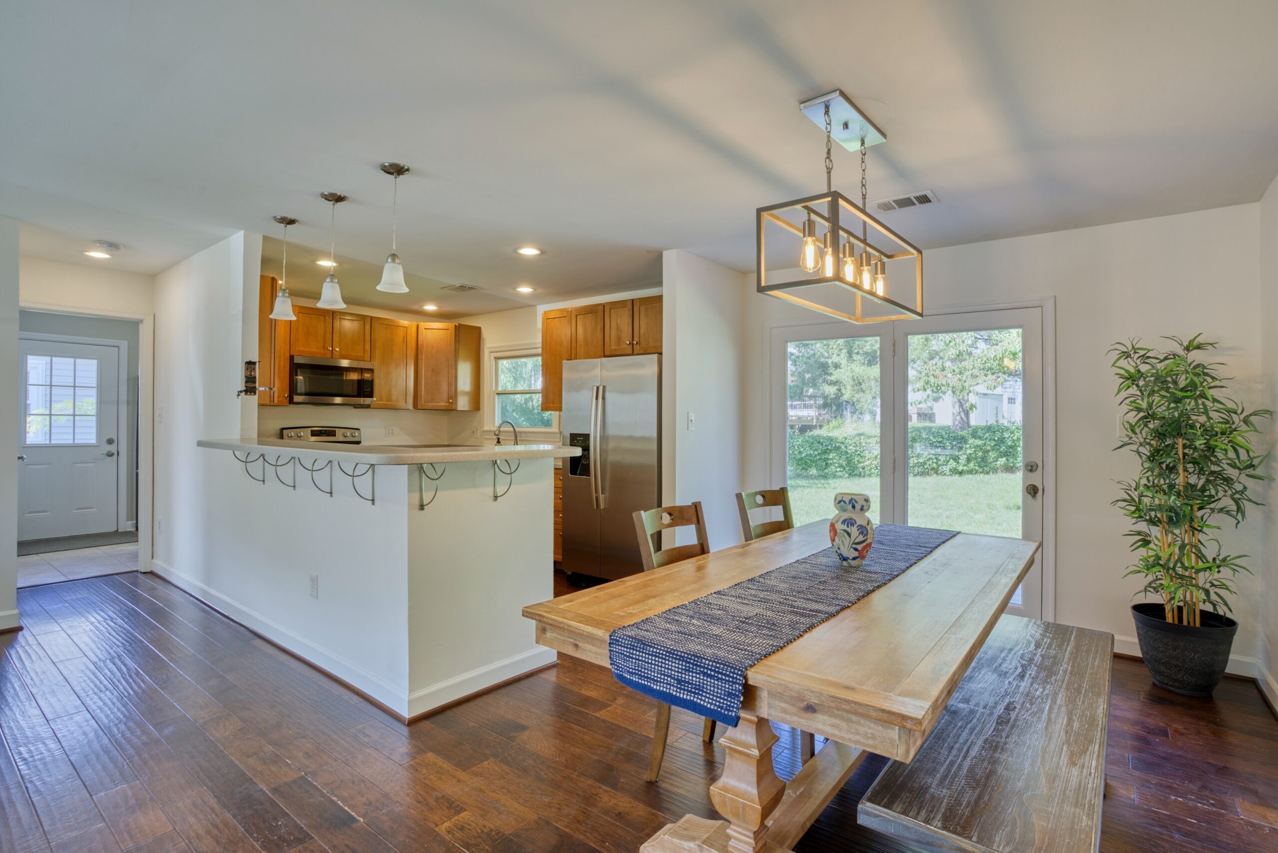 Professional interior photo of 1103 S Greenthorn Ave in Sterling, VA - showing the dining area outside of the kitchen with a high bar top ready for stools