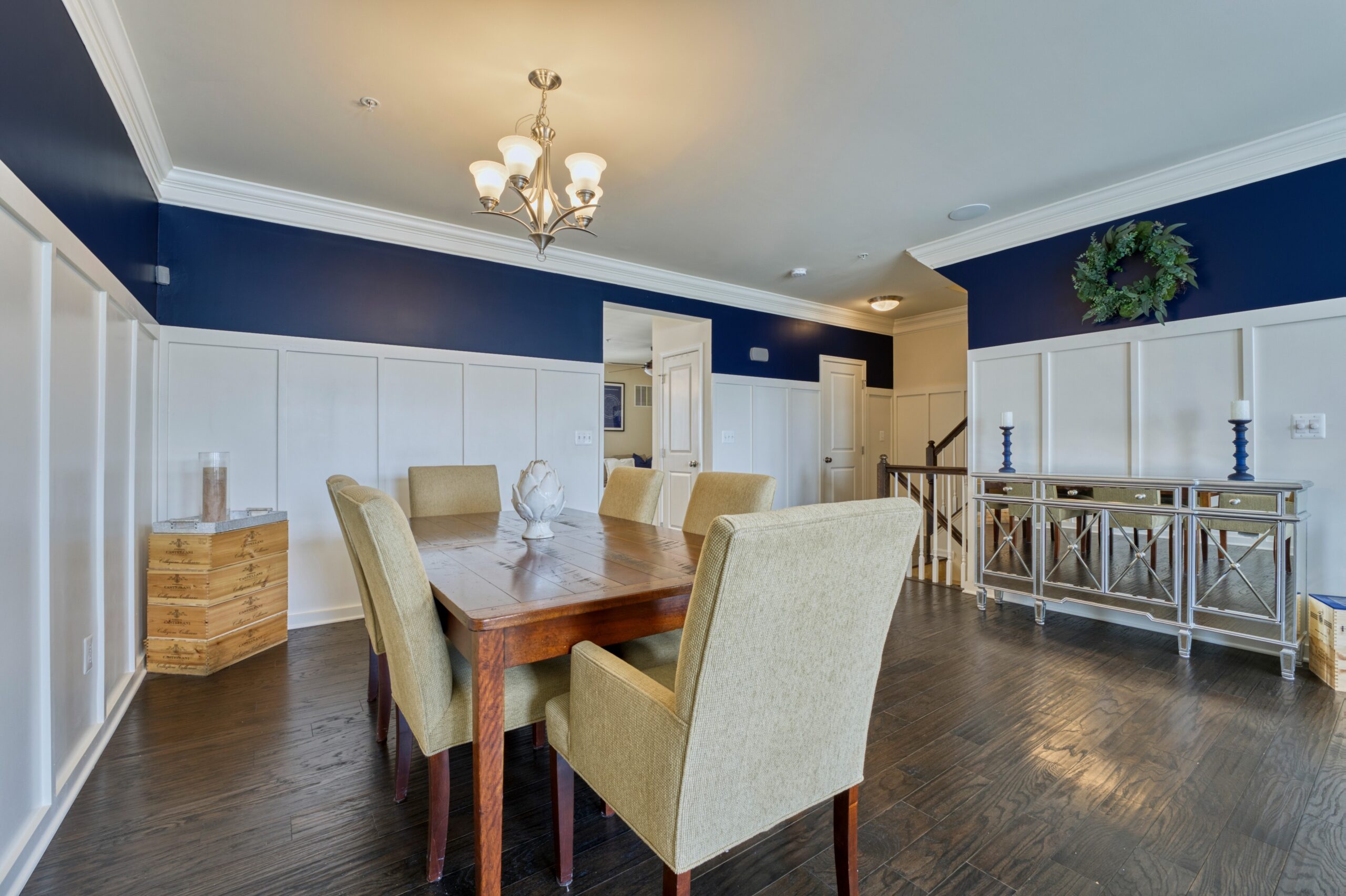 Professional interior photo of 23560 Buckland Farm Ter, Ashburn, VA - Showing the dining area with white wainscoting against white walls bordered by deep blue around the top third of the wall over the wainscoting