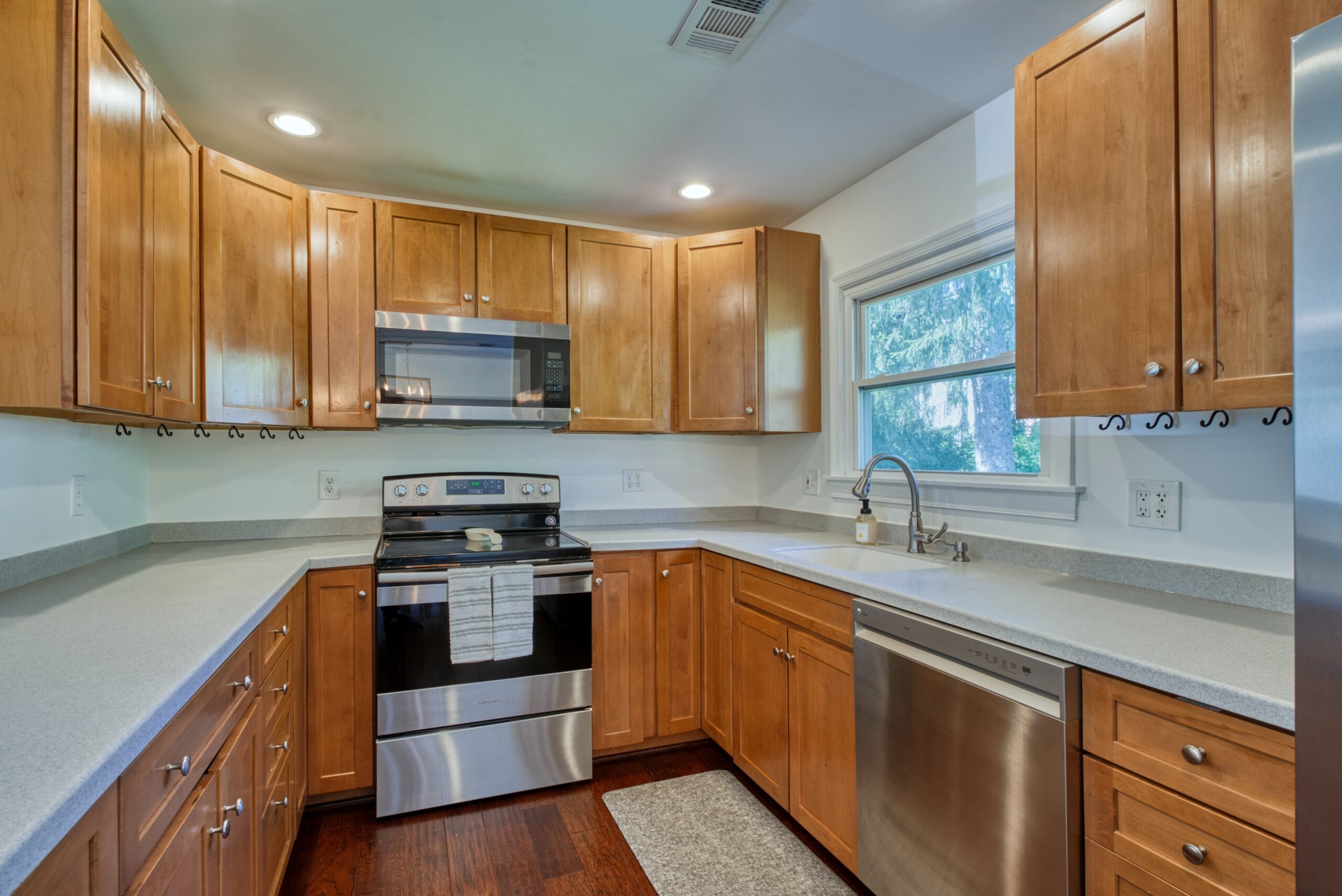 Professional interior photo of 1103 S Greenthorn Ave in Sterling, VA - showing the u-shaped kitchen with abundant counterspace and walnut cabinets
