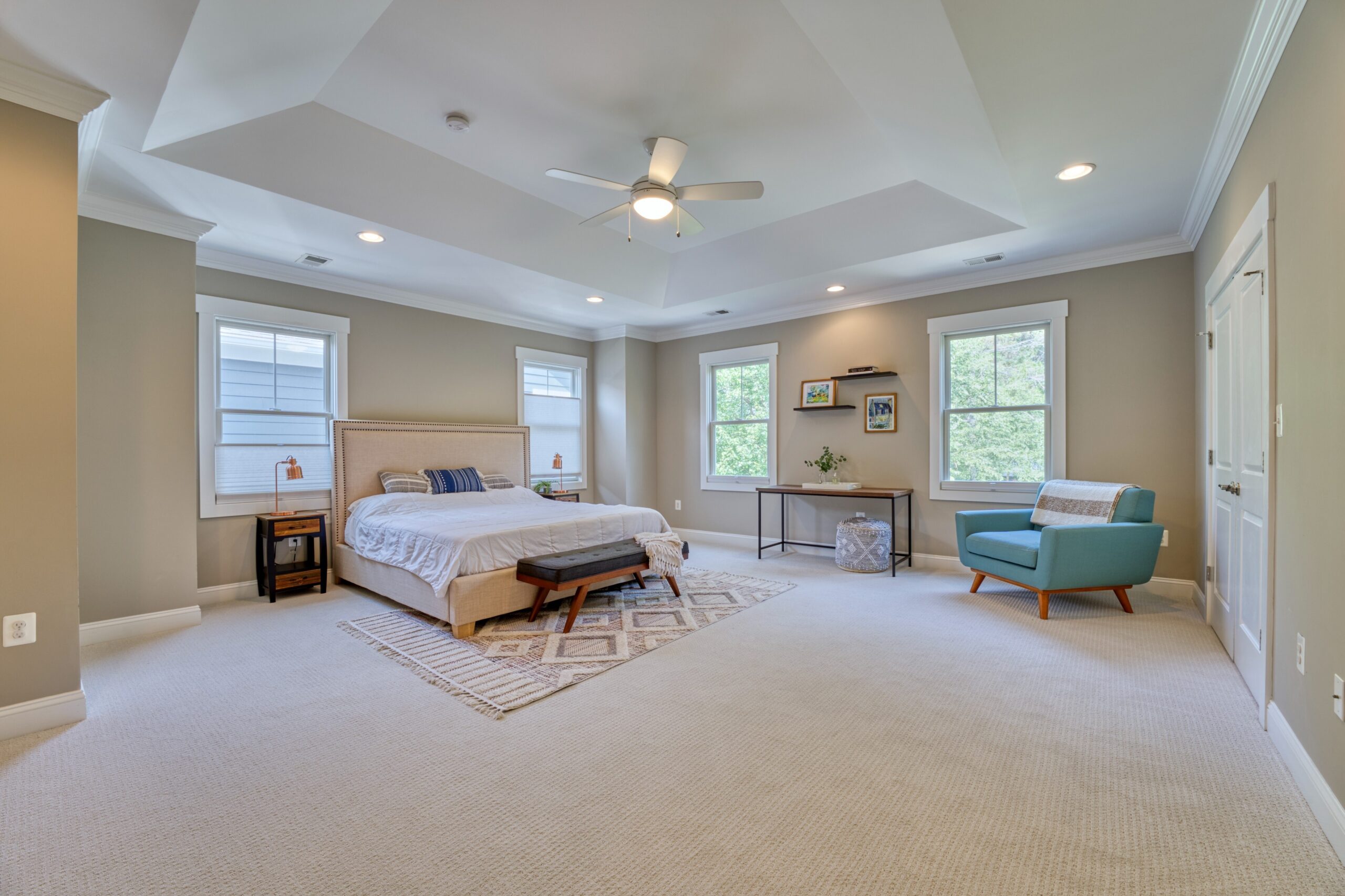 Professional interior photo of 505 N West St - showing the primary bedroom with deep tray ceiling, 4 windows and closet doors