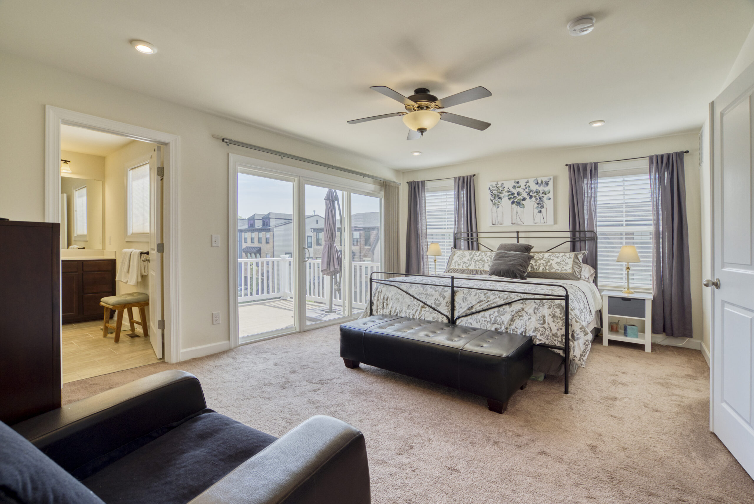 Professional interior photo of 8109 Zoe Place, Alexandria, VA - Showing the primary bedroom suite with sliding door to private balcony