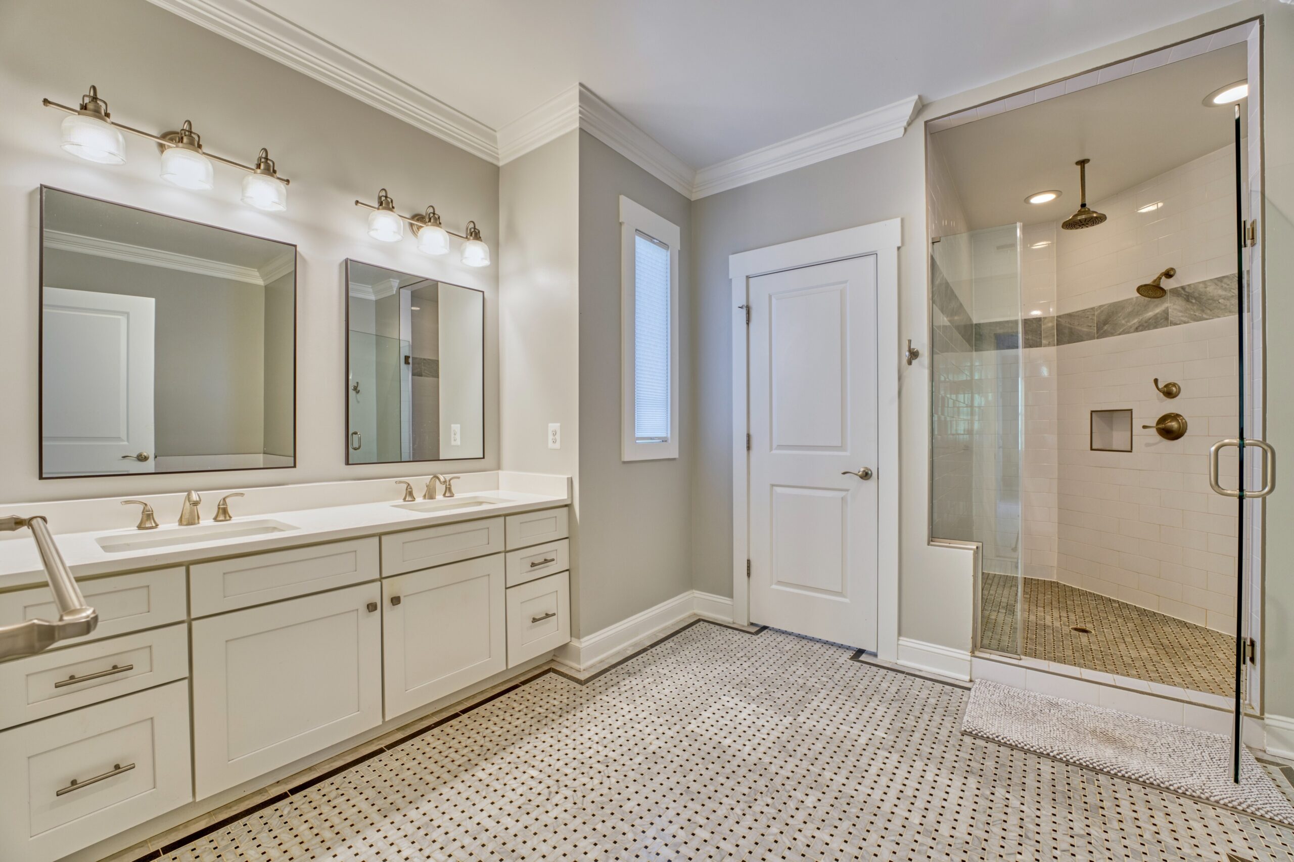 Professional interior photo of 505 N West St - showing the primary bathroom with dual vanity, private commode door next to the large shower with rain head