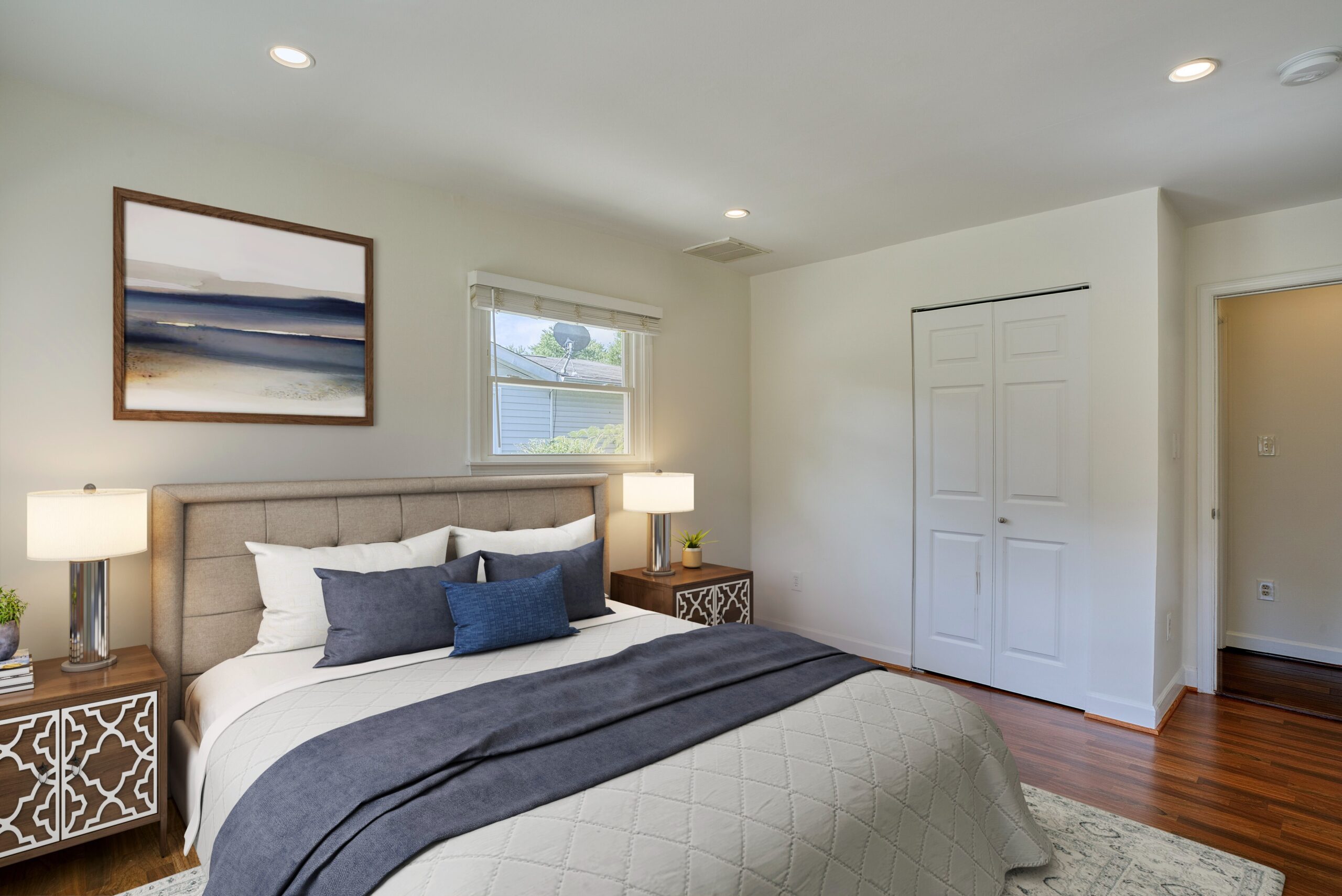 Professional interior photo of 1103 S Greenthorn Ave in Sterling, VA - showing a bedroom with hardwood floors and double door closet which has been virtually staged as a bedroom 