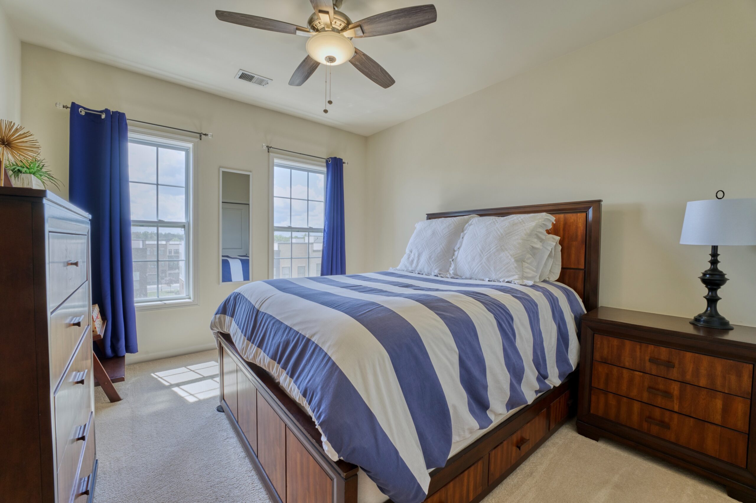 Professional interior photo of 23560 Buckland Farm Ter, Ashburn, VA - Showing the secondary bedroom with 2 large windows and ceiling fan