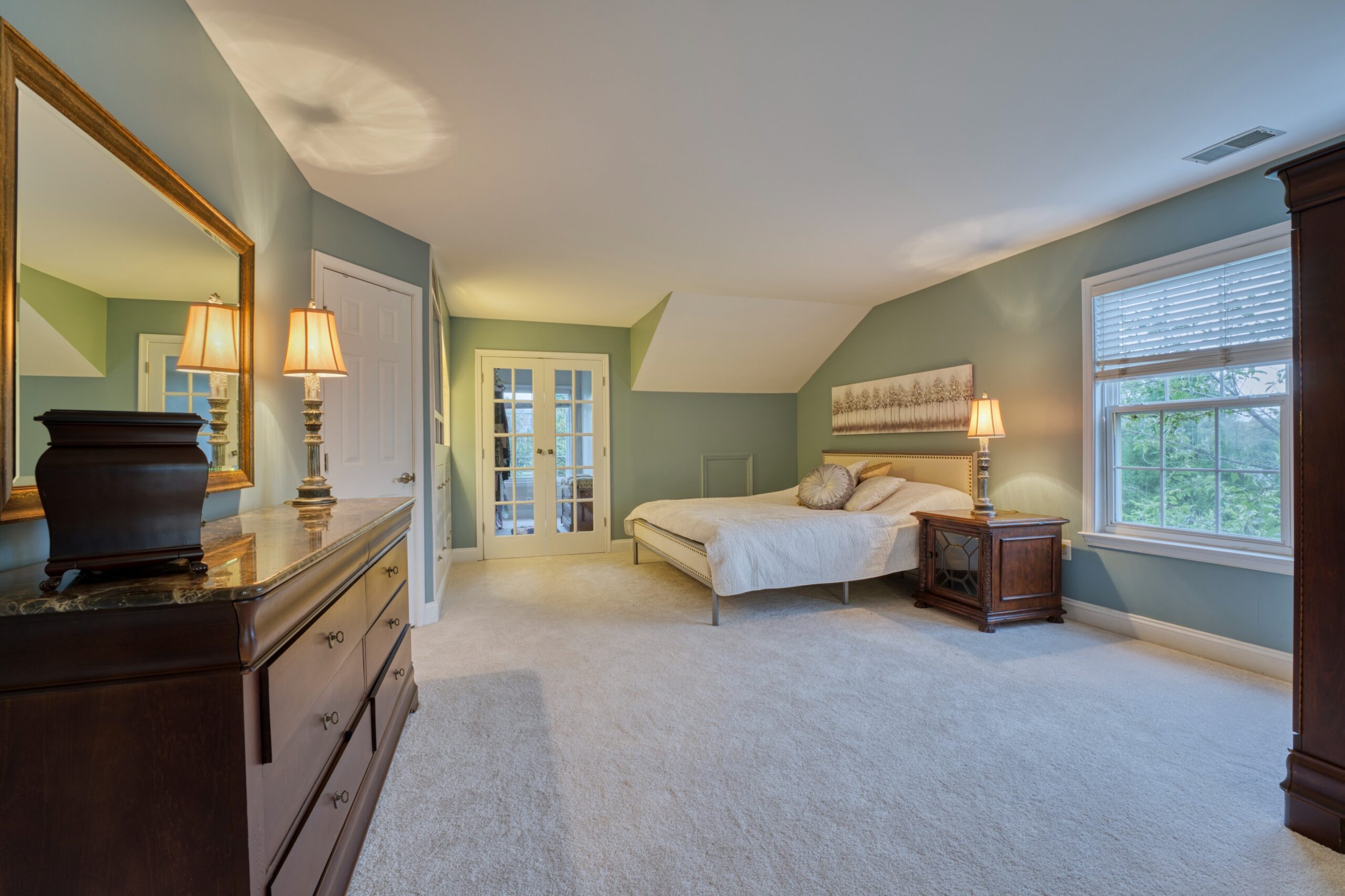 Professional interior photo of 16961 Heather Knolls Pl - showing the primary bedroom with french doors to one of the walk in closets