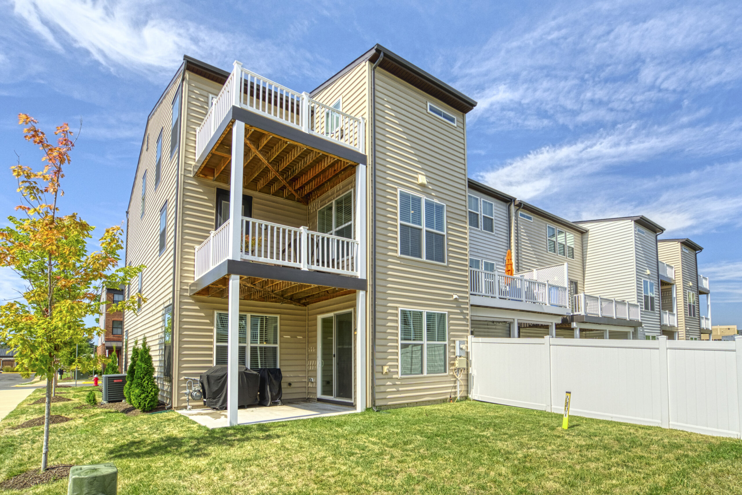 Professional exterior photo of 8109 Zoe Place, Alexandria, VA - Showing the rear of the end unit townhome with 3-level outdoor living space