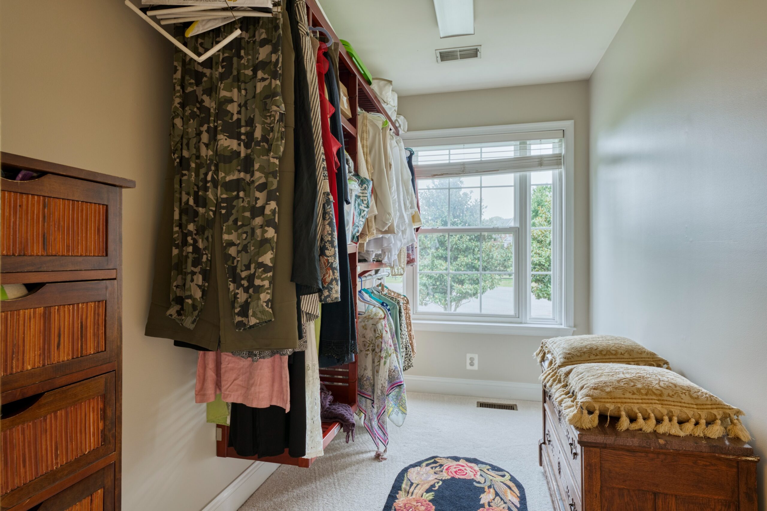 Professional interior photo of 16961 Heather Knolls Pl - showing one of the walk in closets which has a bench and also a window to the exterior