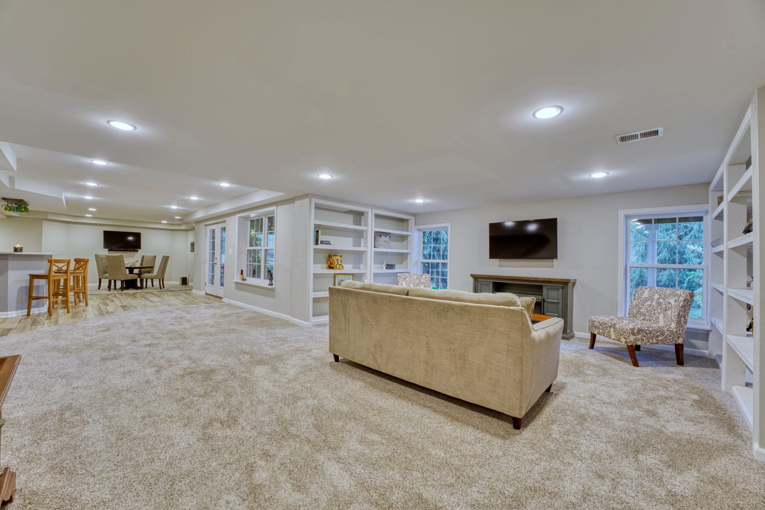 Professional interior photo of 16961 Heather Knolls Pl - showing the finished basement with living area with built in shelves, and sitting area and bar in the background