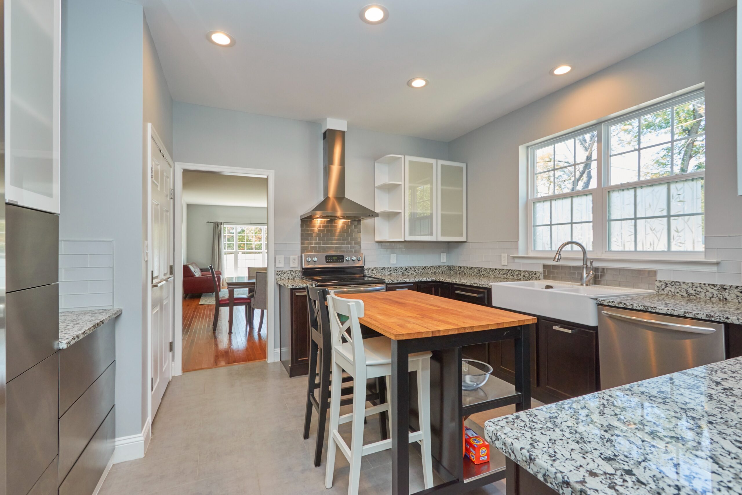 Professional interior photograph of 384 C Street - showing the kitchen with granite counters, stainless appliances and butcher block island with stools and storage