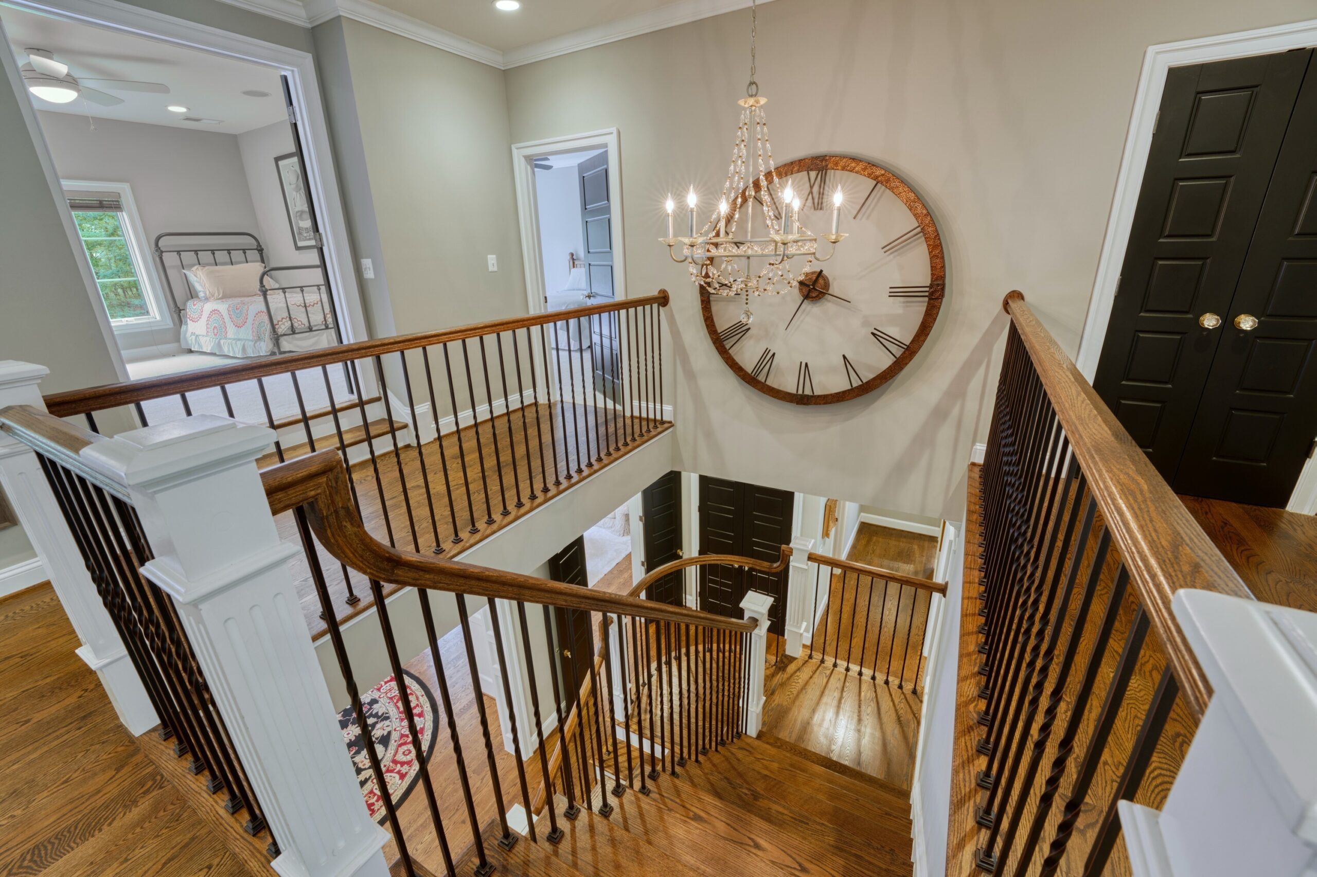 Professional interior photo of 40046 Mount Gilead Rd in Leesburg, Virginia - showing the staircase looking down from the upper floor. The railing is oak and the spindles are black iron