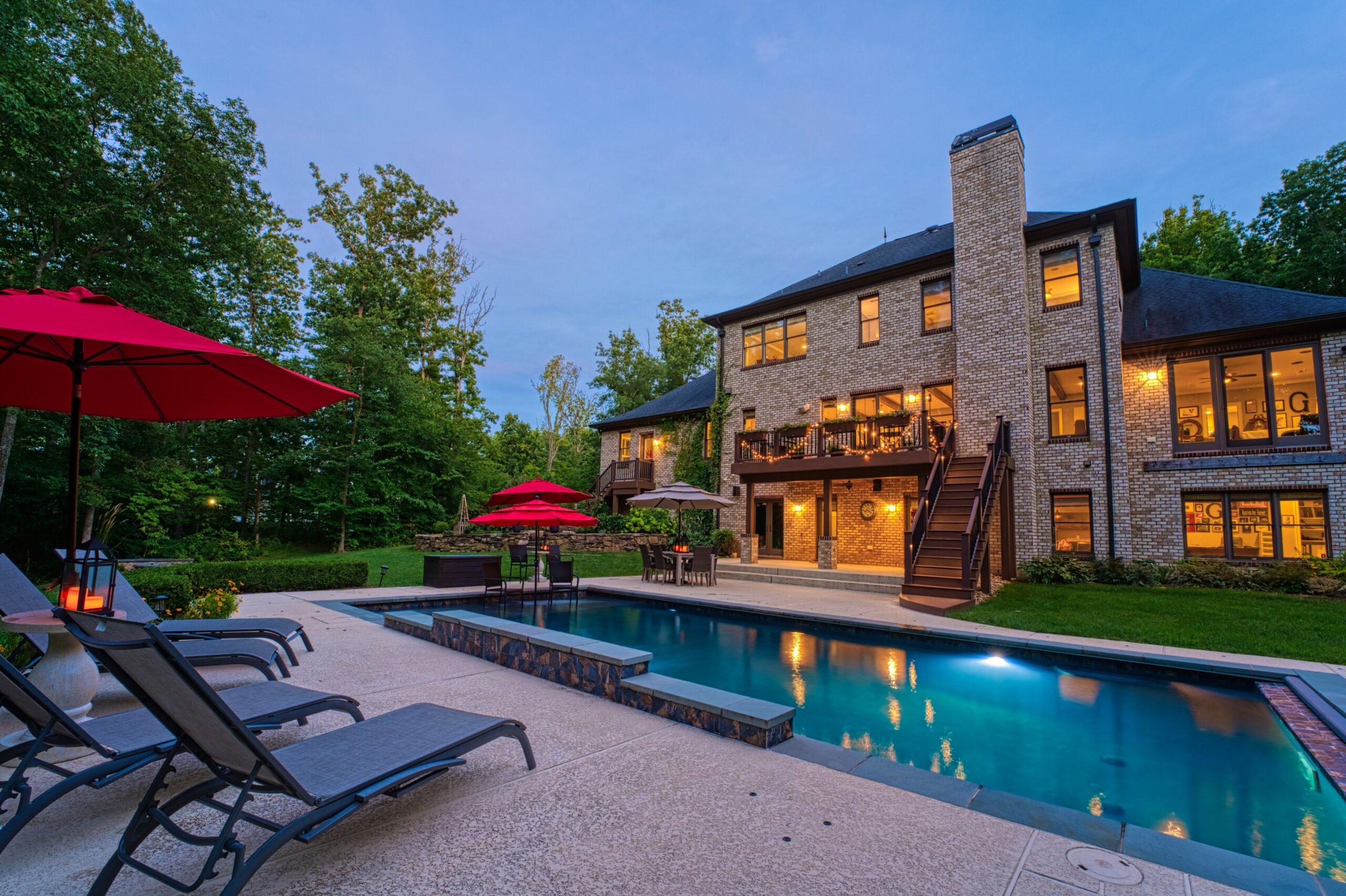 Professional exterior photo of 40046 Mount Gilead Rd in Leesburg, Virginia - showing the rear of the home at dusk from behind the pool