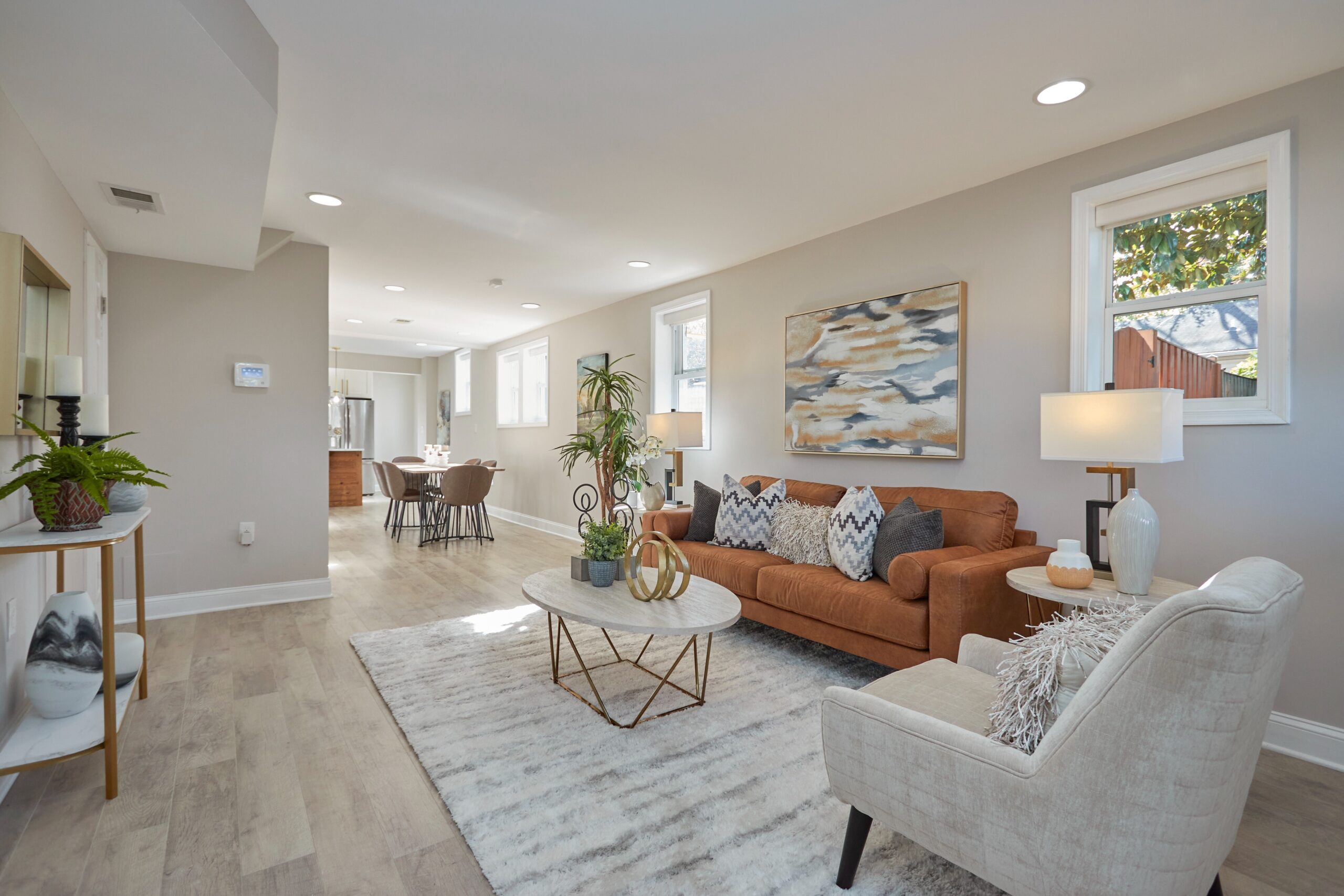Professional interior photo of 1219 50th St NE in Washington, DC - showing the living room that flows openly back through the dining room to the kitchen