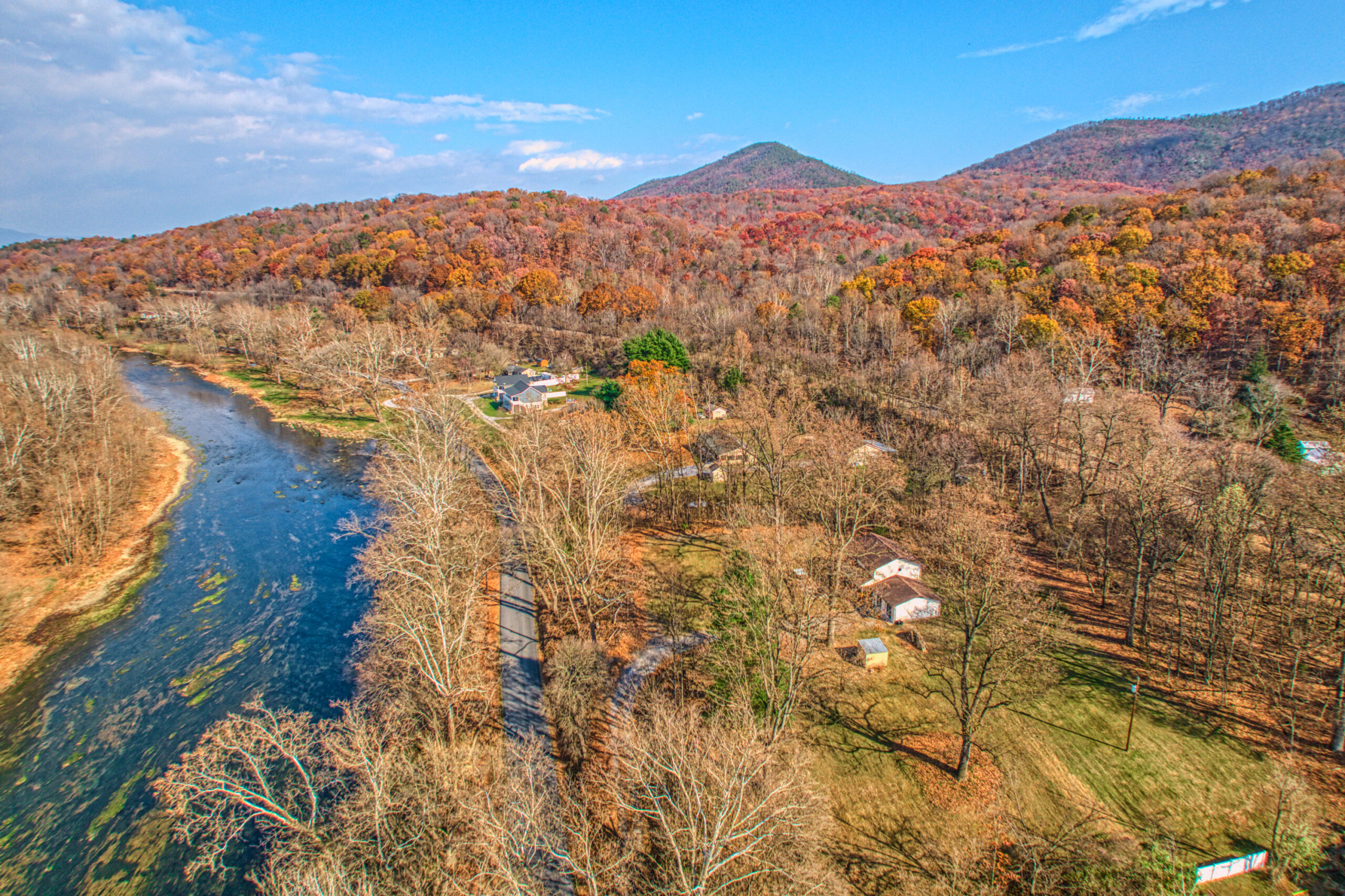 Professional exterior photo of 4809 Grove Hill River Rd - aerial shot of the Home across the road from the shenandoah river with beautiful fall foliage