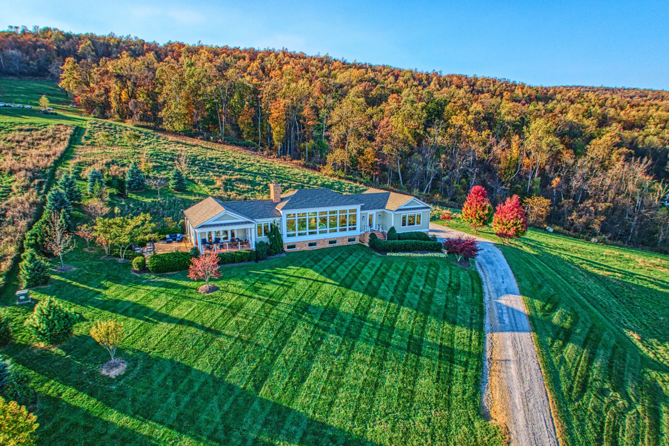 Professional exterior photo of 17151 Brookdale Ln in Round Hill, VA - showing the aerial view of the front of the home with large windows all across the front of the contemporary home