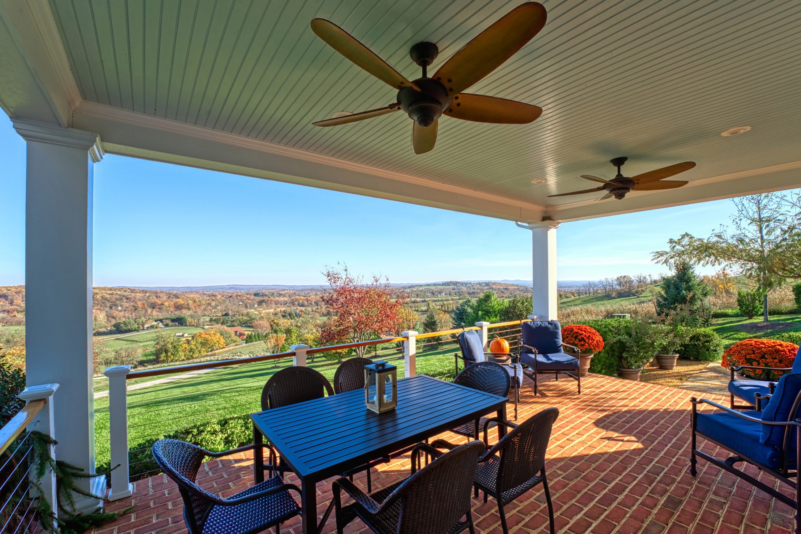 Professional exterior photo of 17151 Brookdale Ln in Round Hill, VA - showing the large covered brick patio with views of the country valley