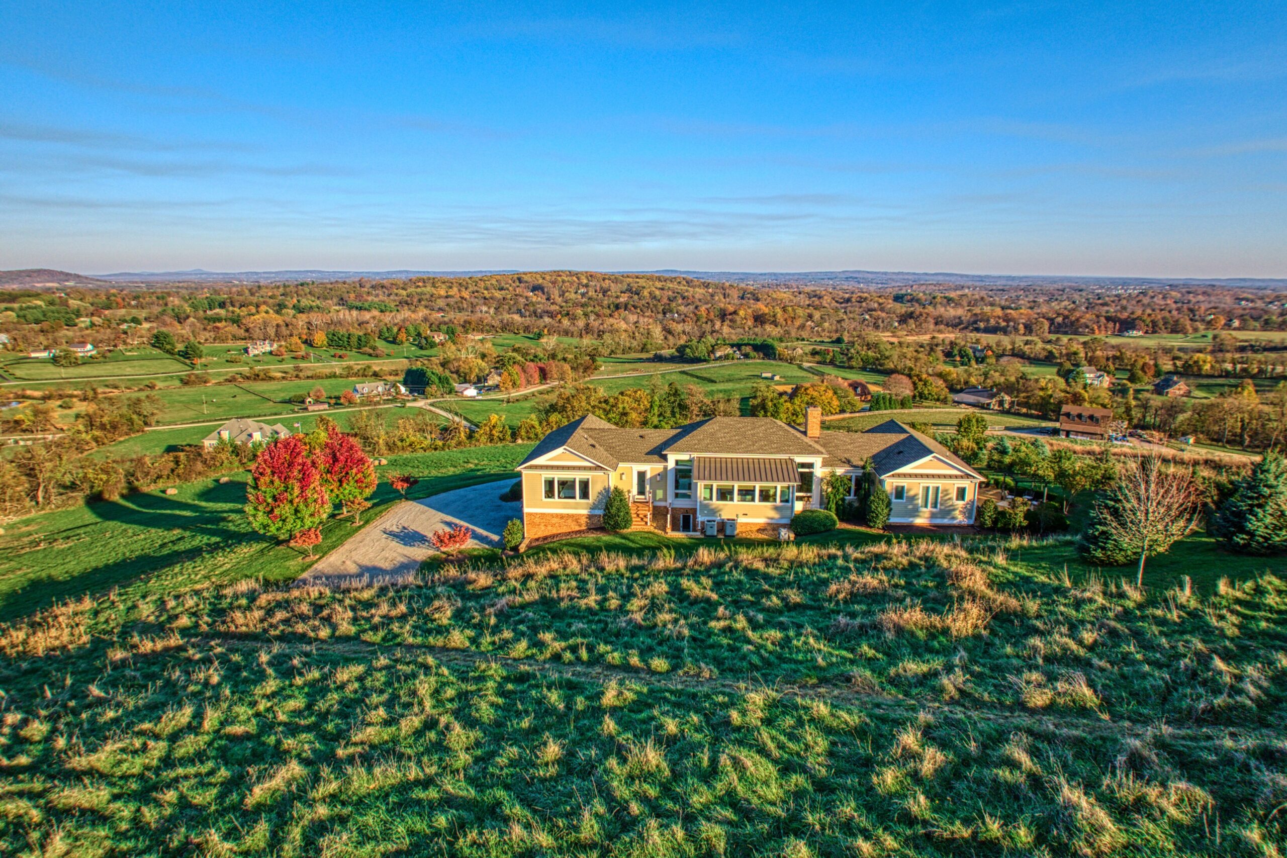 Professional exterior photo of 17151 Brookdale Ln in Round Hill, VA - showing the aerial view of the back of the home, views of the countryside below
