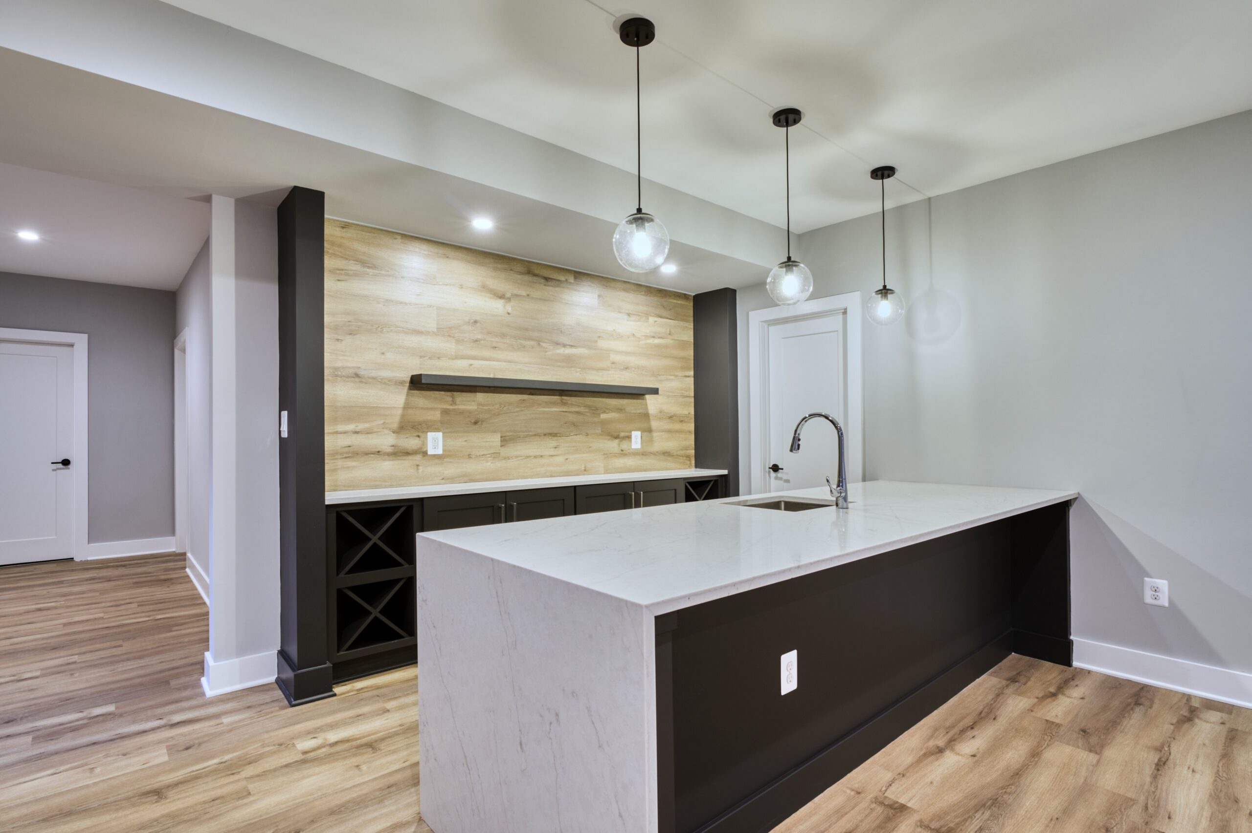 Professional interior photo of new construction home at 3400 N Ohio St - showing the basement bar with large island, sink, wine rack and bottle dislplay