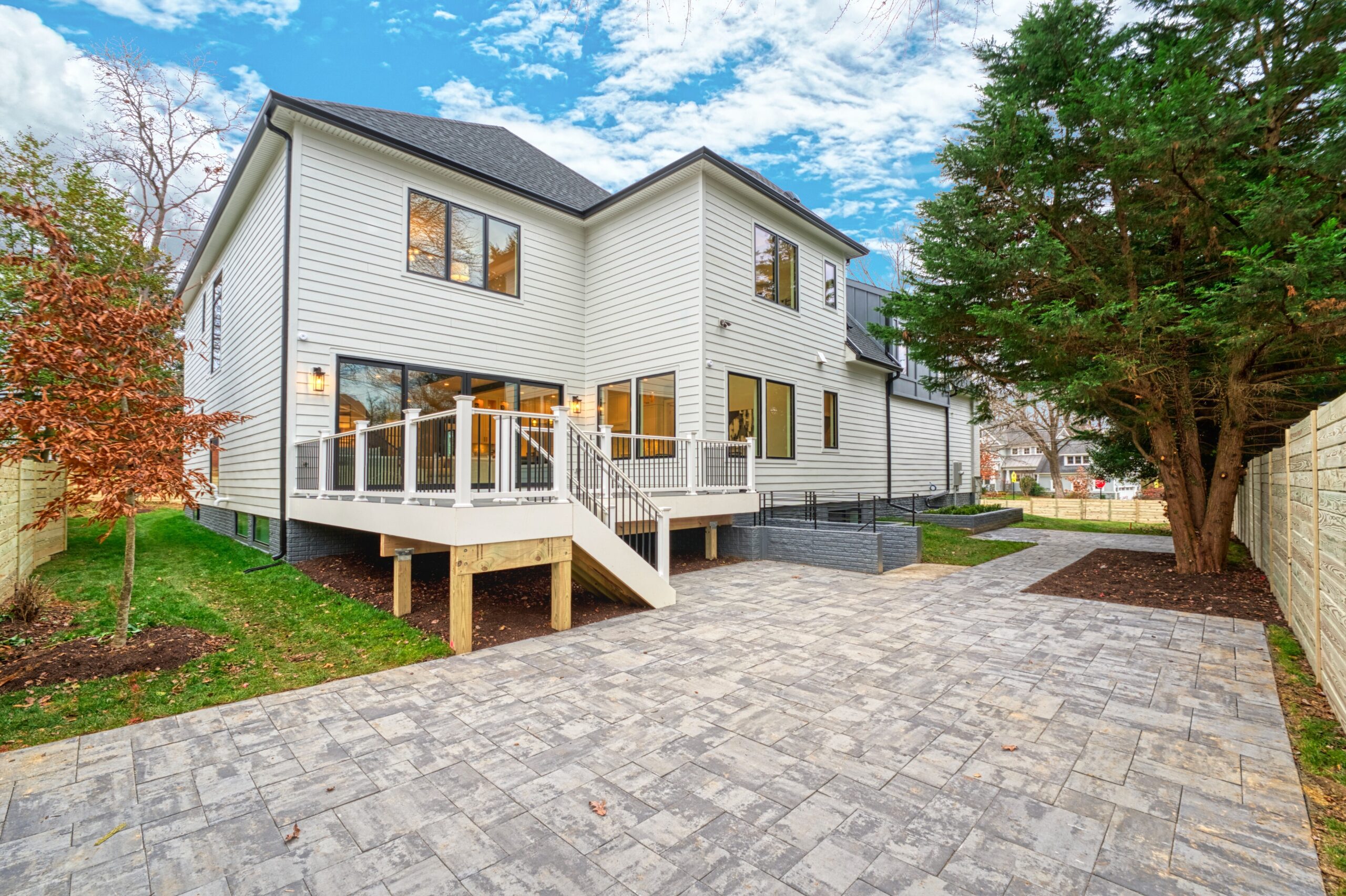 Professional exterior photo of 3400 N Ohio St - showing the rear of the home with large deck over expansive stone patio all within a fully fenced yard
