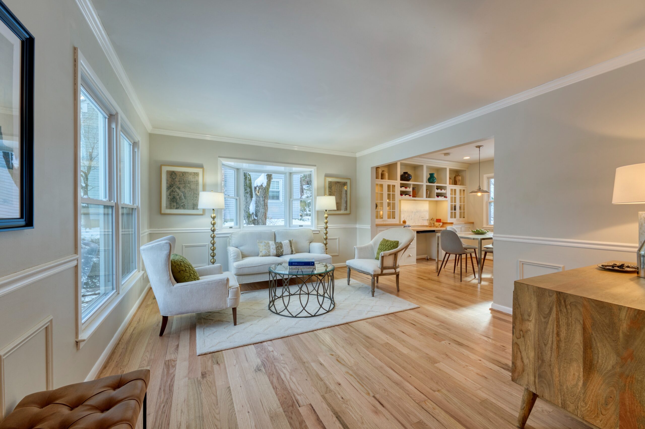 Professional interior photo of 9515 Center St in Vienna, Virginia - showing the front formal living room with hardwood floors and kitchen eating area in the far background