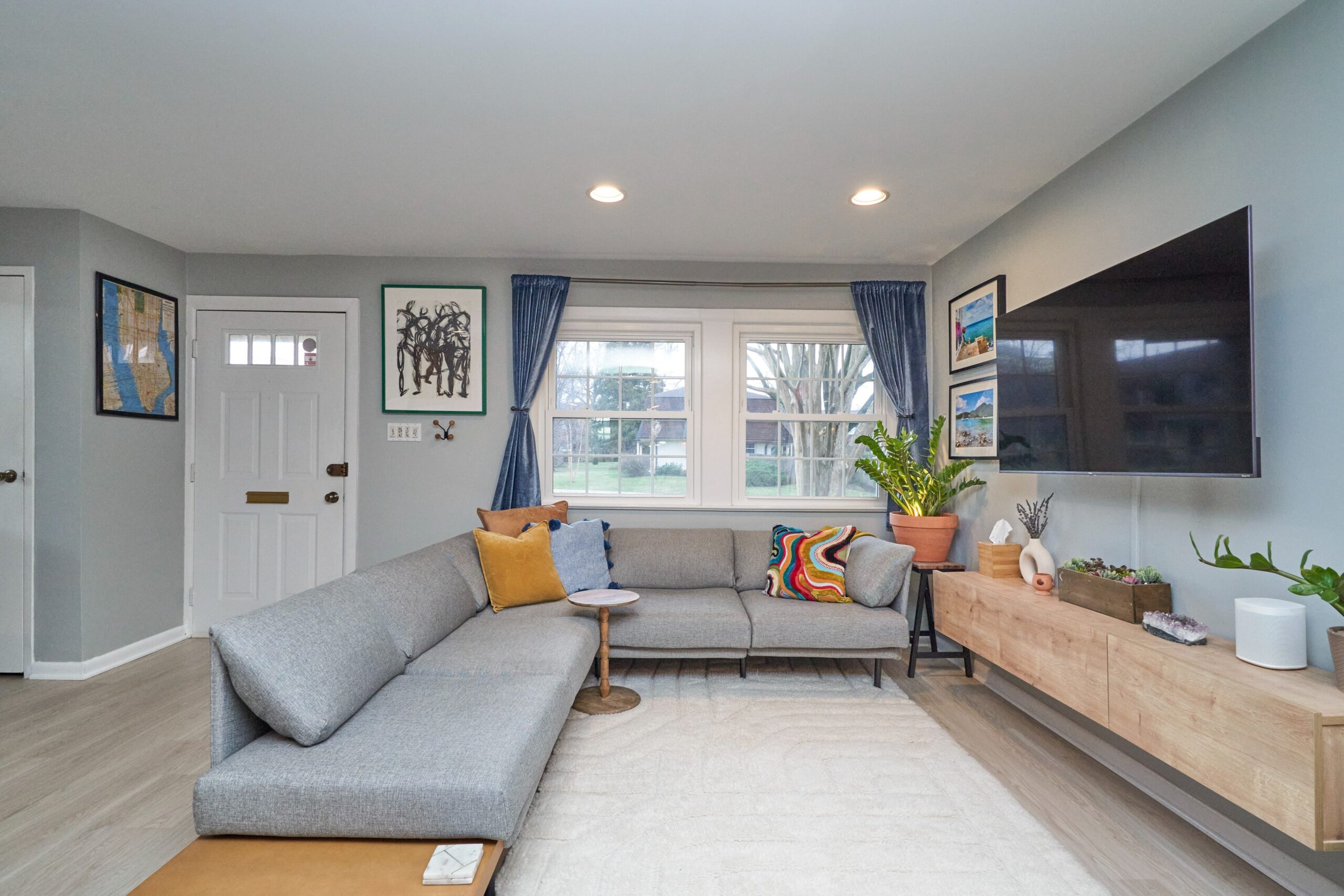 Professional interior photo of 415 James Ct in Falls Church City - showing the main floor living space with bright living room, modern furniture and mounted flat screen tv