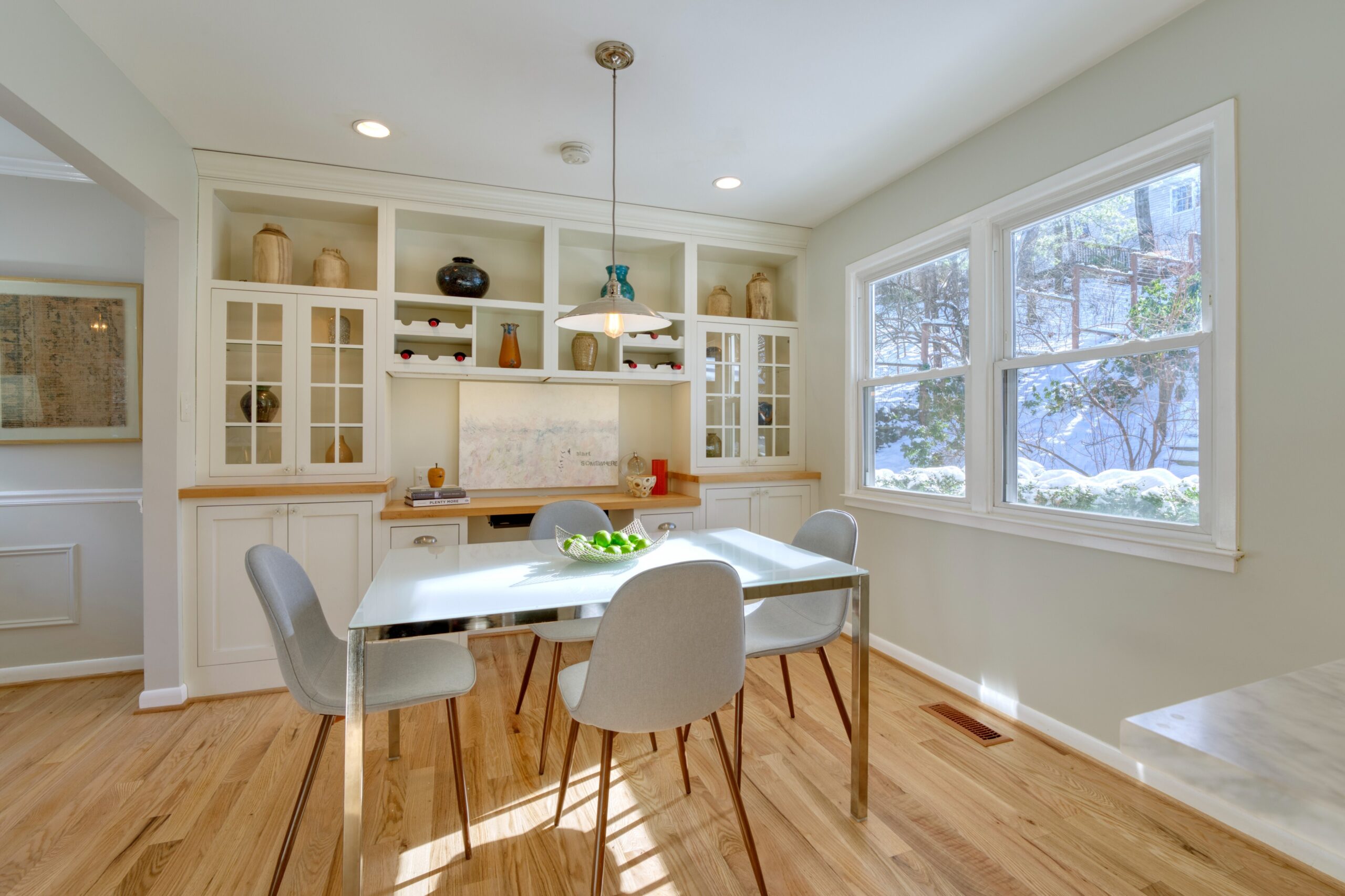 Professional interior photo of 9515 Center St in Vienna, Virginia - showing the kitchen eating area with table in front of built in shelves and a desk space