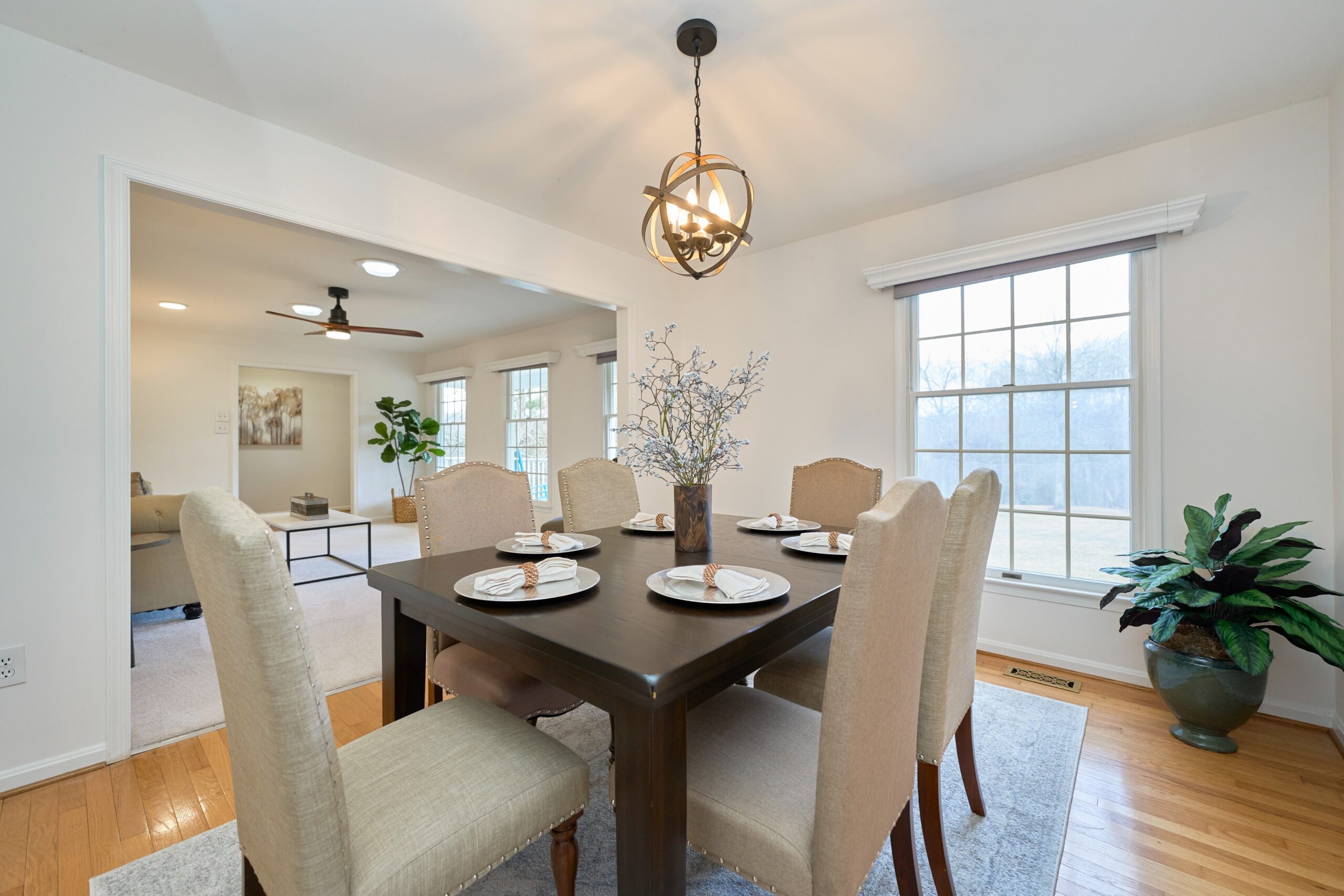 Professional interior photo of 3103 Indian Run Rd - showing the dining room with modern light fixture, hardwood floors and front sitting room in the background