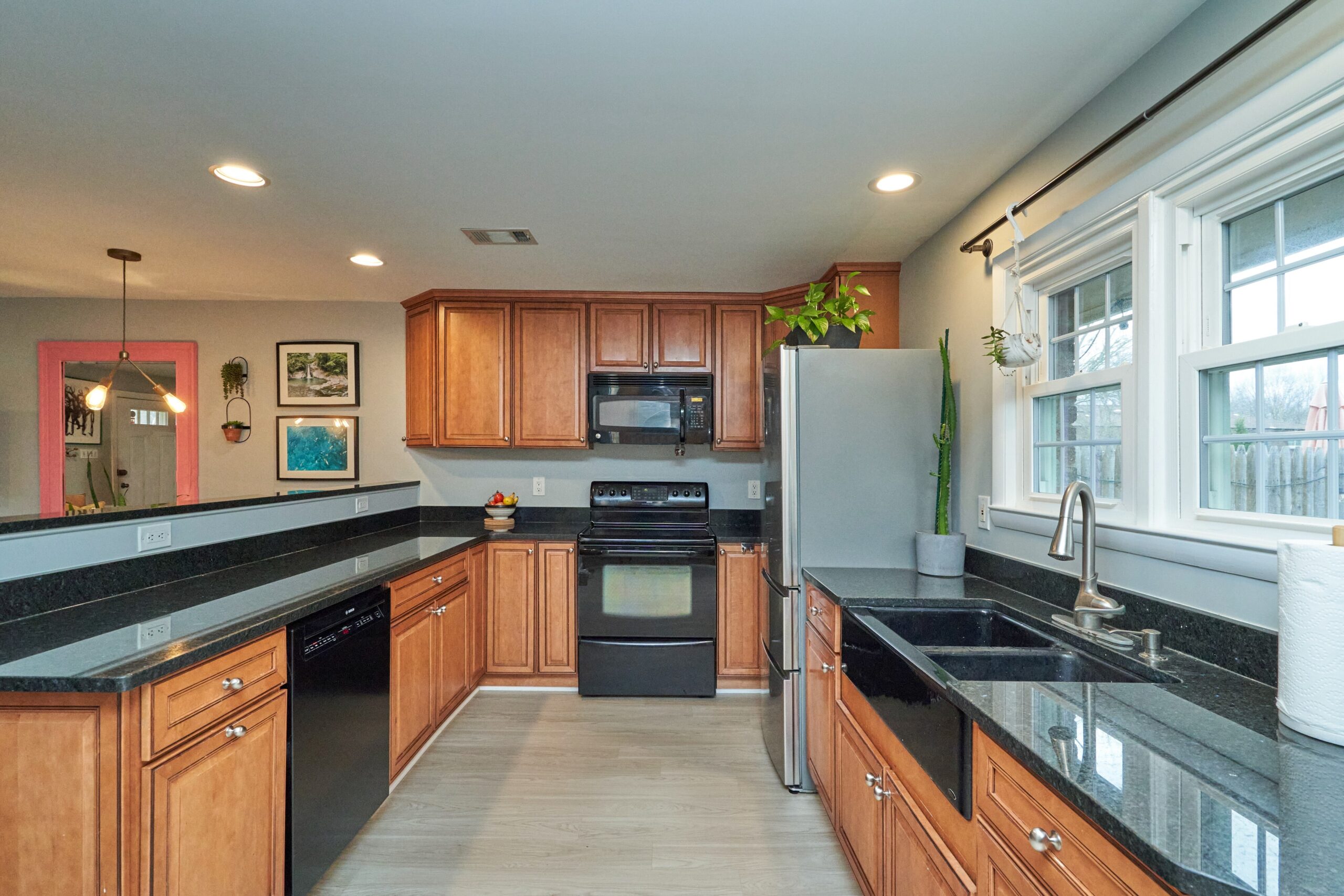 Professional interior photo of 415 James Ct in Falls Church City - showing the kitchen with high bar top over regular counter, wooden cabinets, farm sink and stainless updated appliances