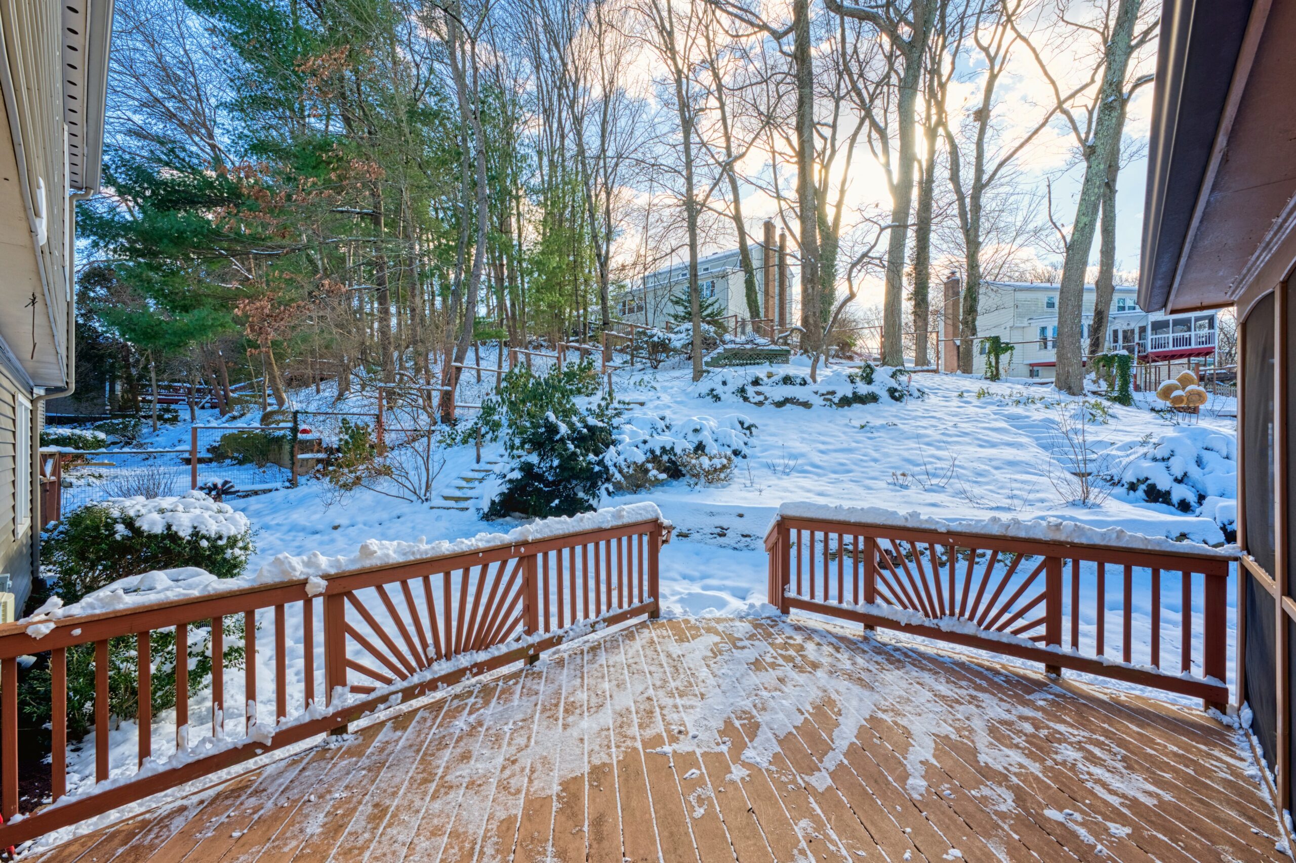 Professional exterior photo of 9515 Center St in Vienna, Virginia - showing the view from the door to the screened porch out over the uncovered deck on a snowy day